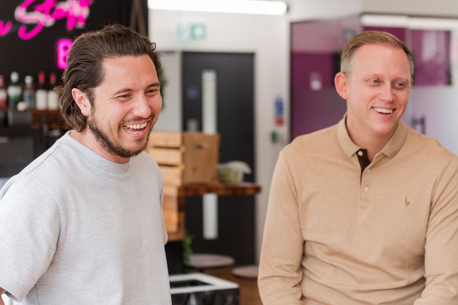 Two professionals having a casual conversation in a modern office space.