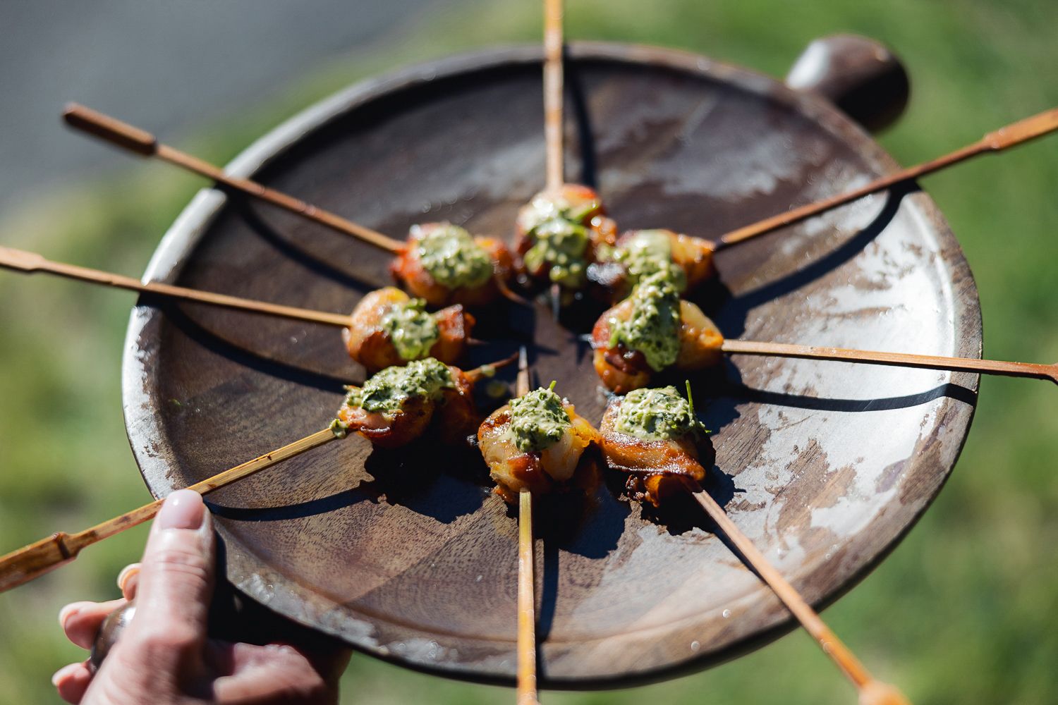 Close-up view of appetizers served on wooden skewers with garnish on rustic plates.