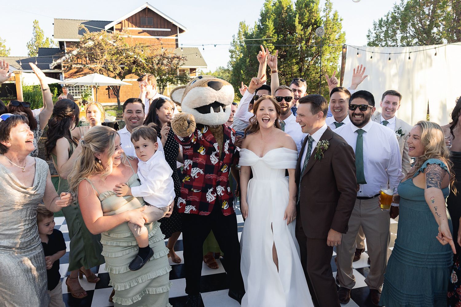 A fun wedding celebration on an outdoor patio with guests in formal attire enjoying a festive atmosphere.
