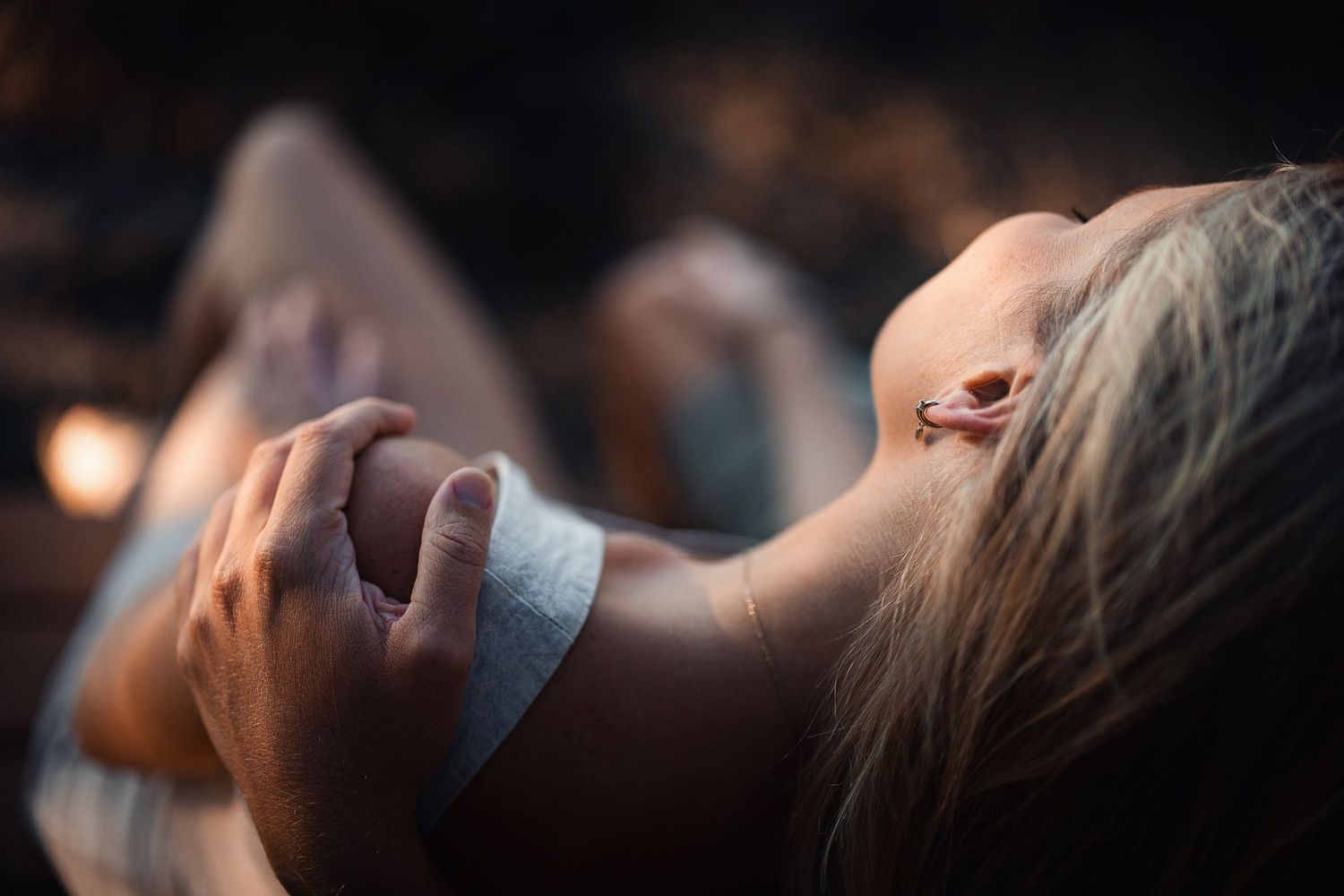 A dramatic close-up shot of someone laid back with eyes closed in soft lighting.
