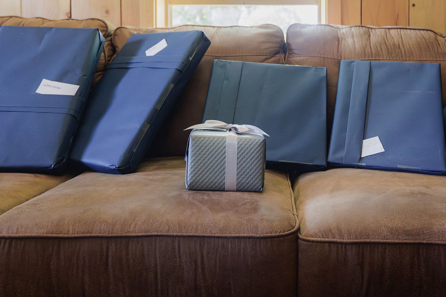 Navy blue furniture cushions and tan leather couch set arranged in a retail showroom setting.
