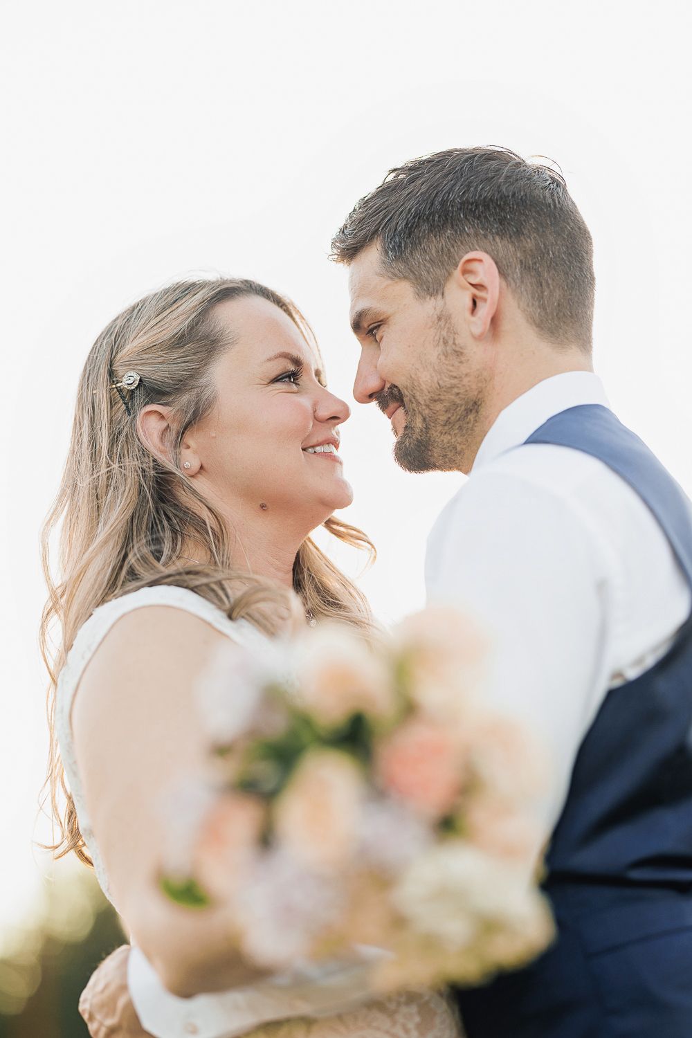 Romantic wedding couple sharing an intimate moment in soft natural lighting.