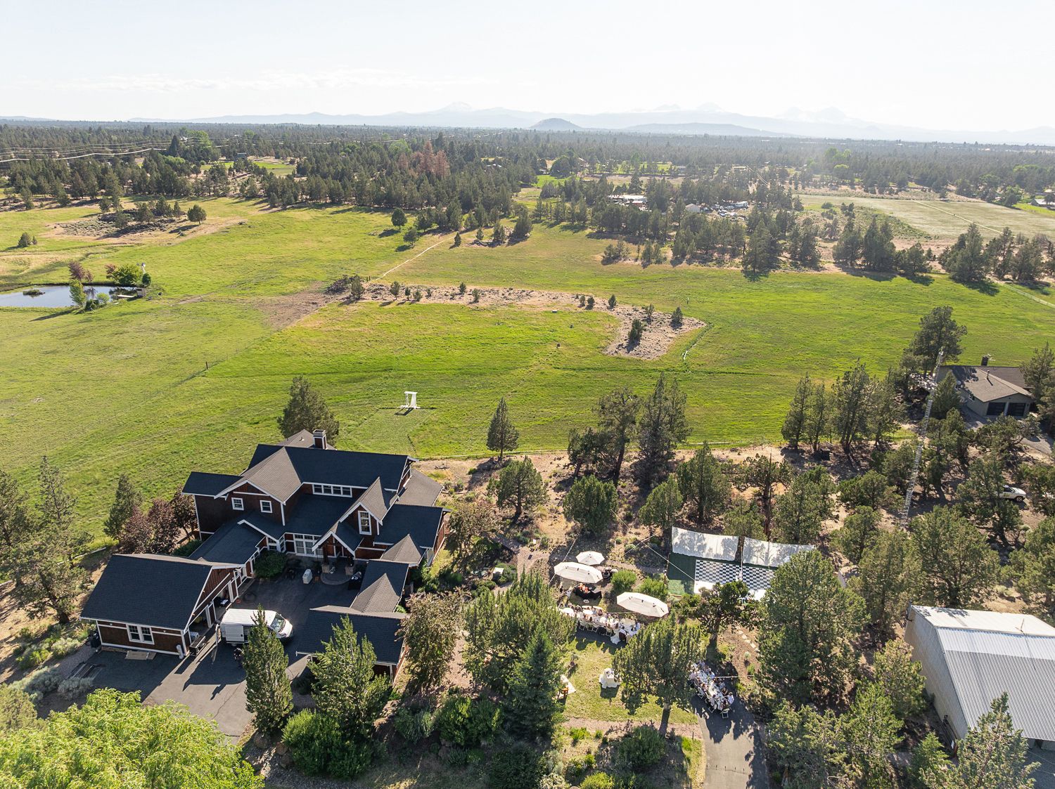 Six aerial photos show a diverse housing development surrounded by rolling green hills and pine trees.