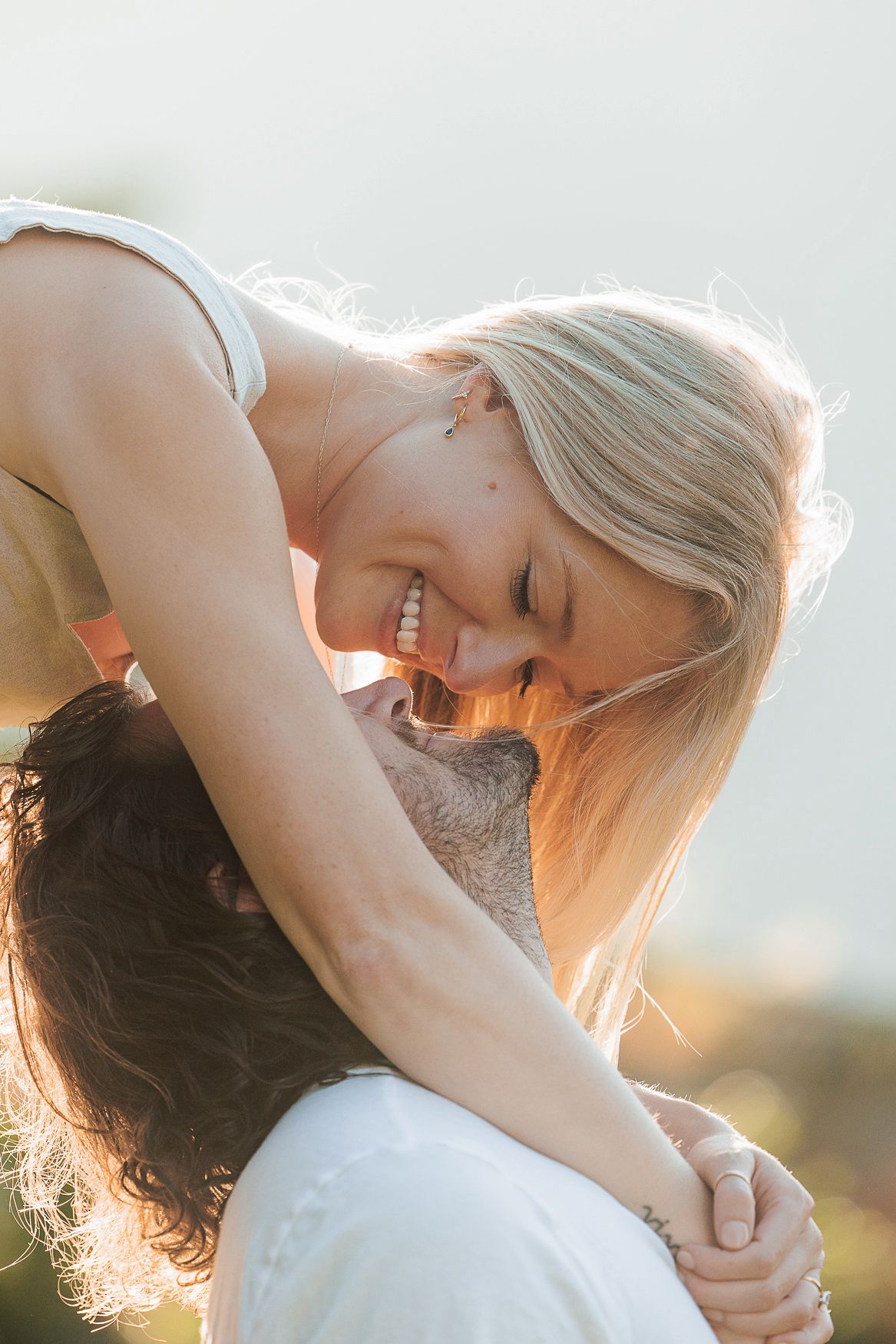 Scenic sunset photo showing a warm embrace between a couple in a romantic moment.