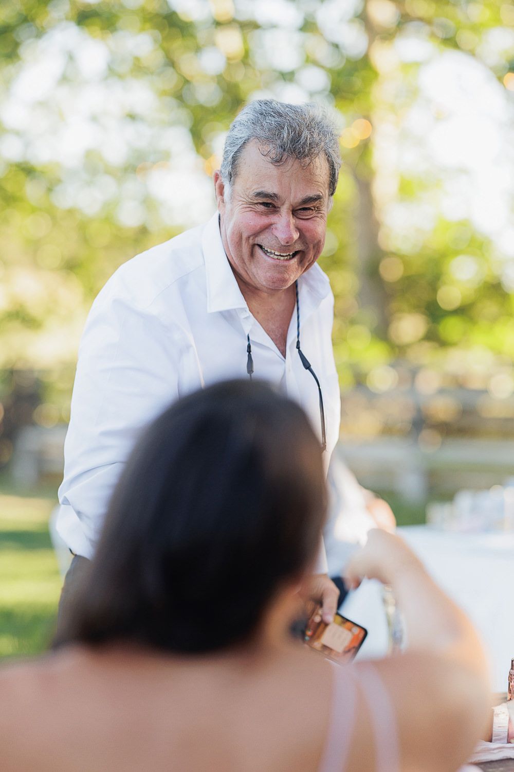 A candid moment from a joyous outdoor celebration in natural lighting.