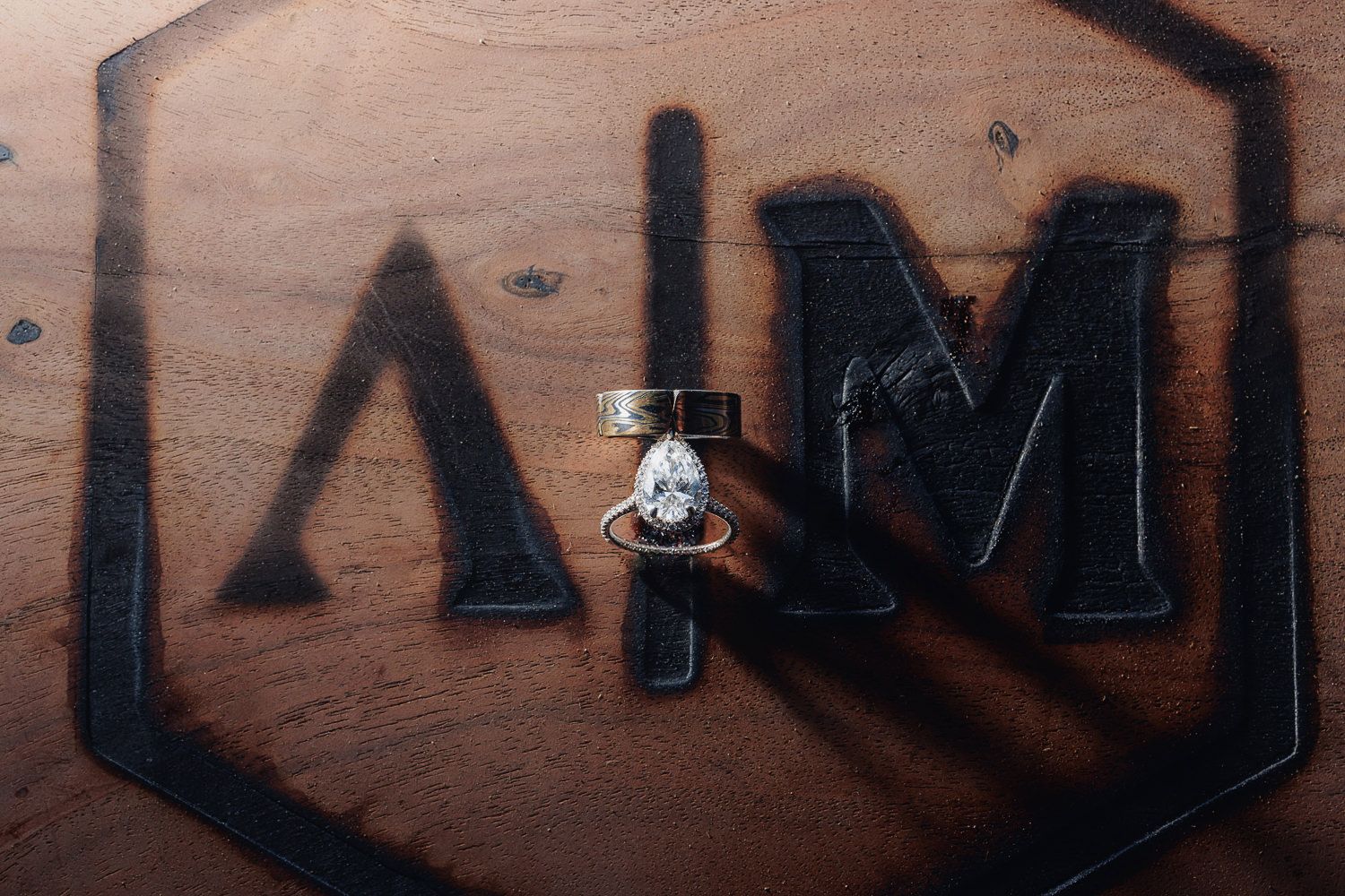 Small light fixture mounted between black geometric letters on a wooden surface.