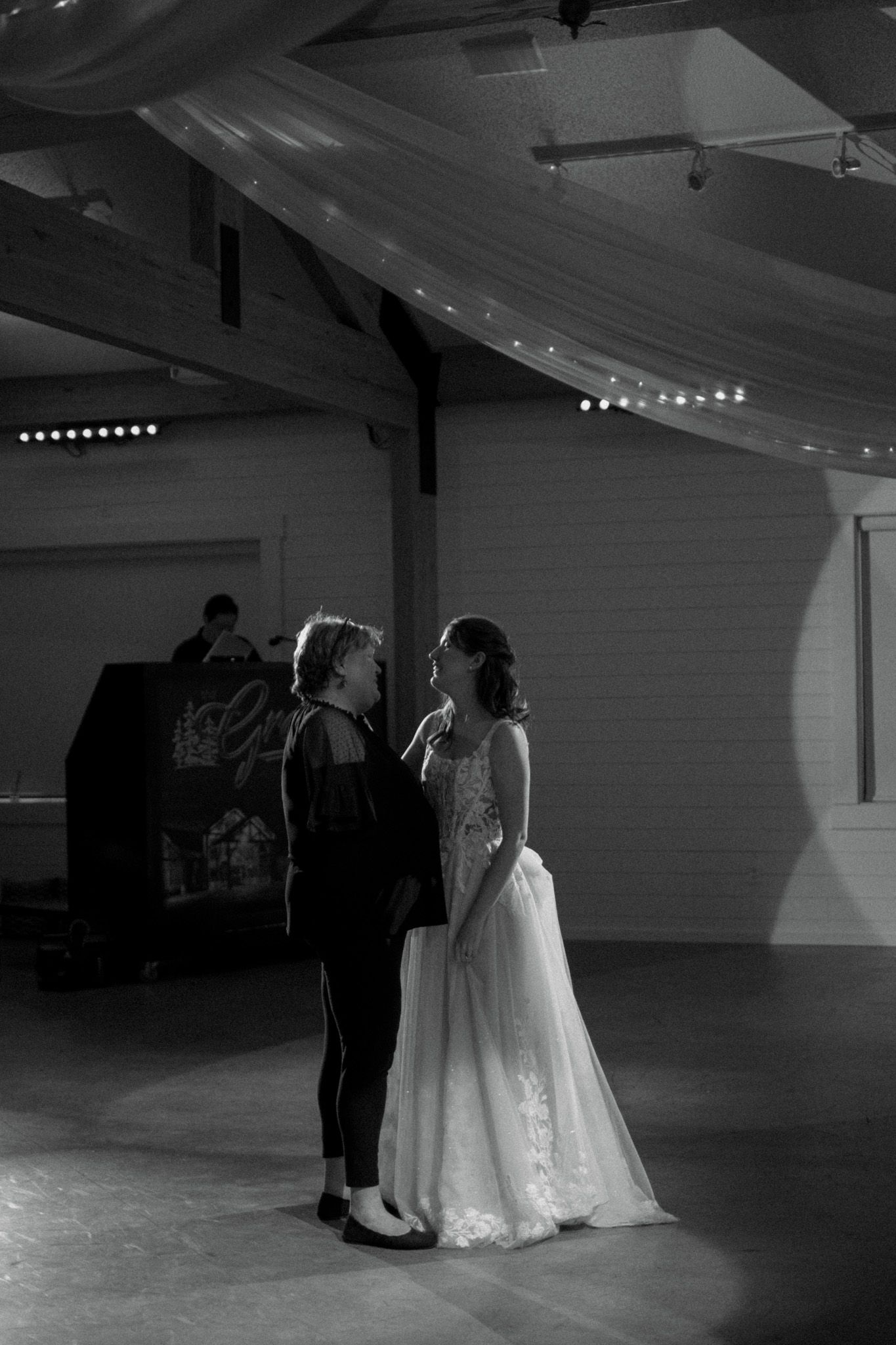 A tender moment between a couple during their wedding reception in a beautifully lit venue.