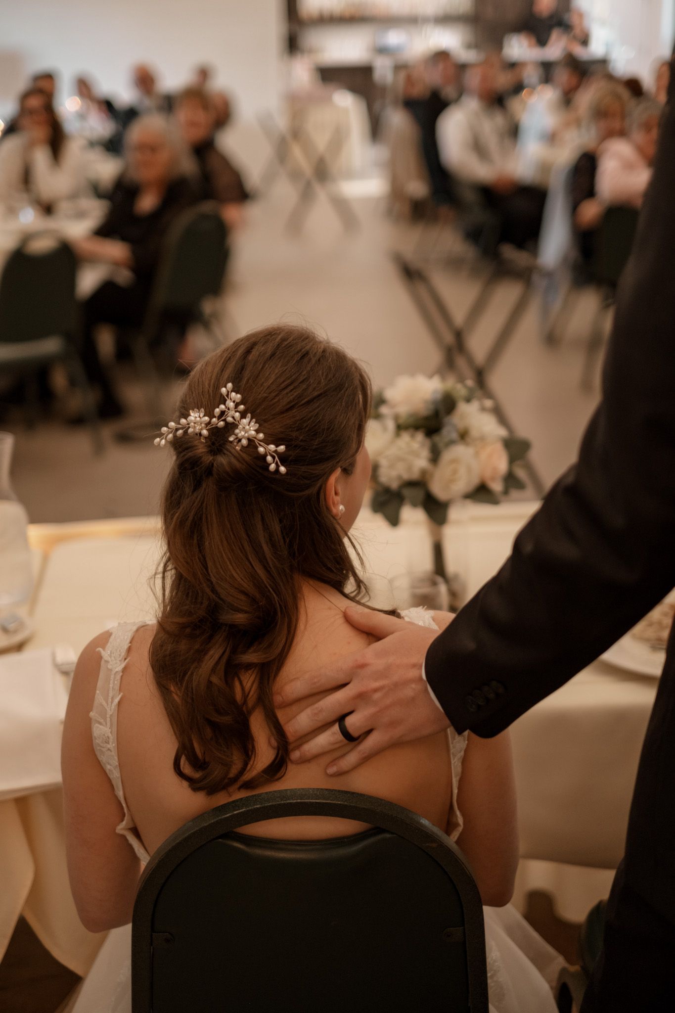 An intimate moment captured of a couple at a wedding reception with decorative floral centerpieces.