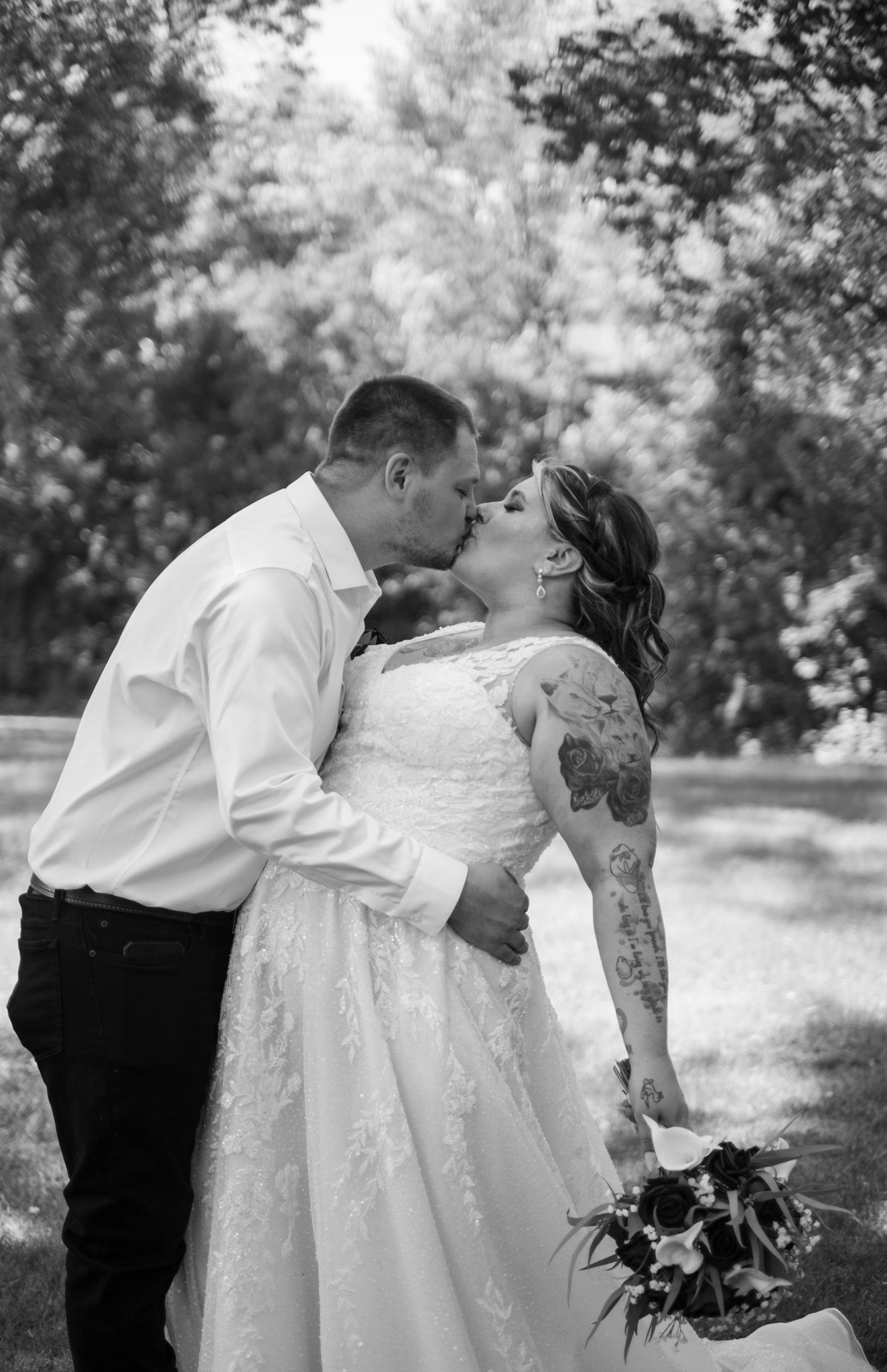 A romantic black and white photo series of newlyweds sharing intimate moments in a peaceful outdoor garden setting.