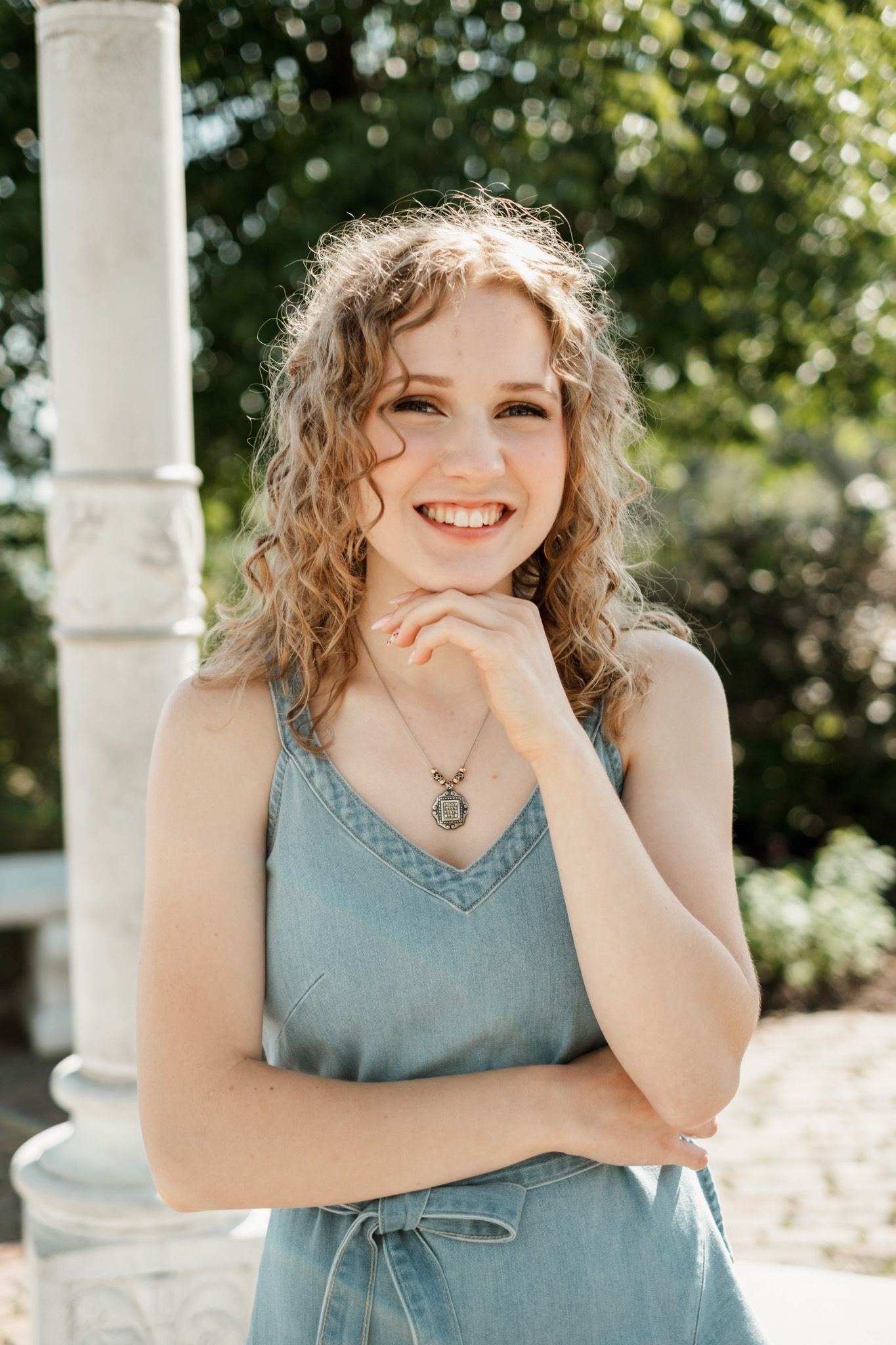 A series of expressive outdoor portraits showing someone in a blue sleeveless top against a sunlit garden background.