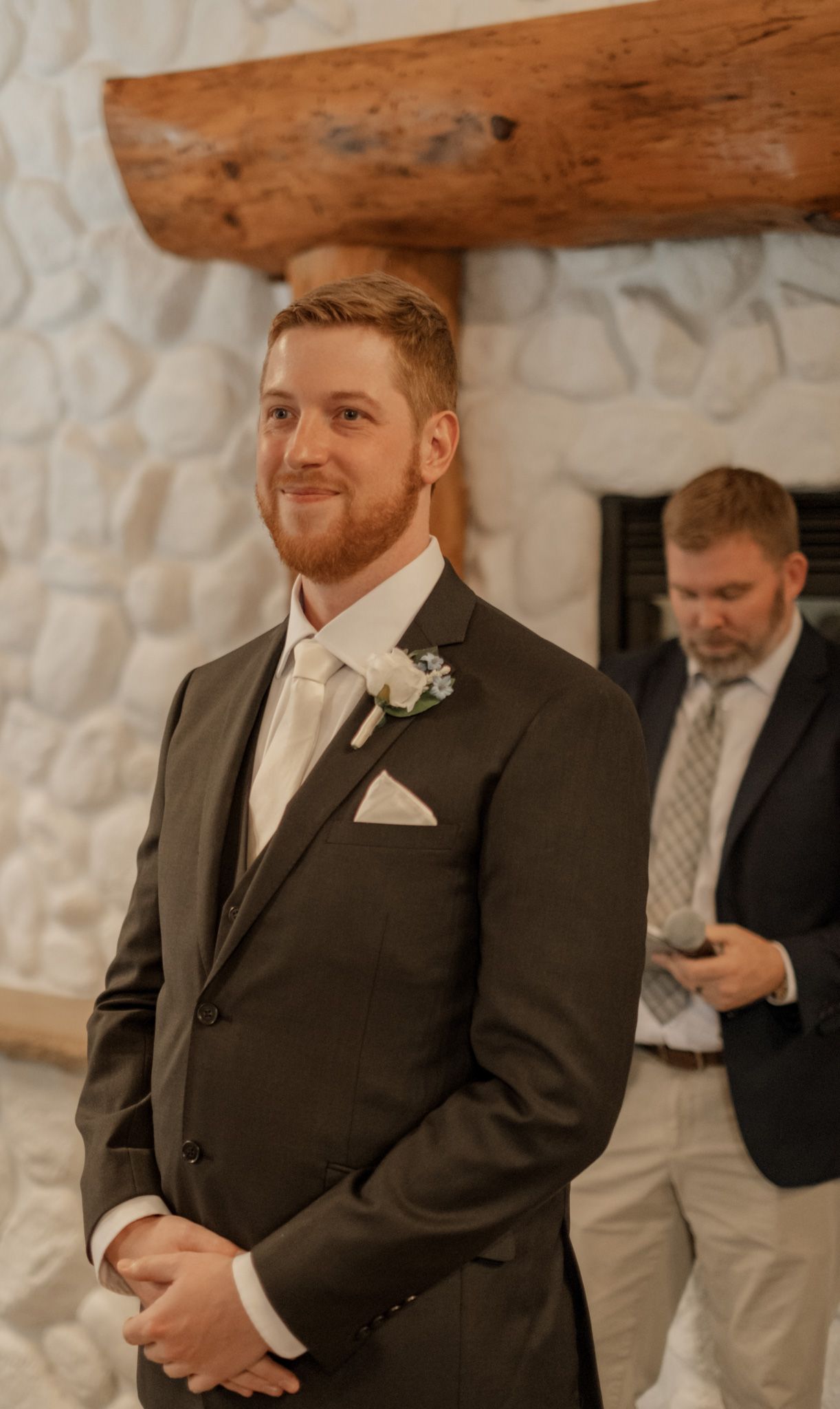 Wedding scene at a rustic stone venue with formal attire.
