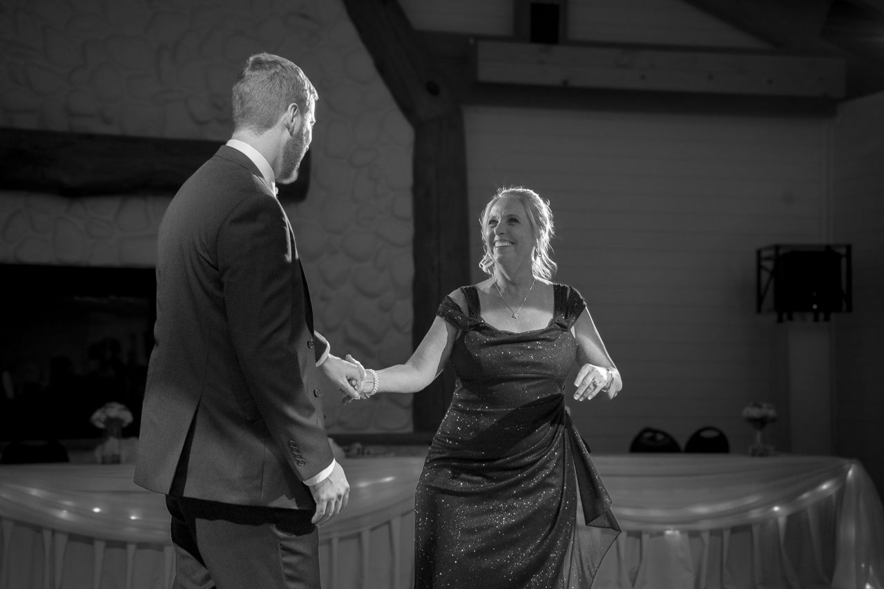Black and white photo of a couple dancing together at their wedding reception.
