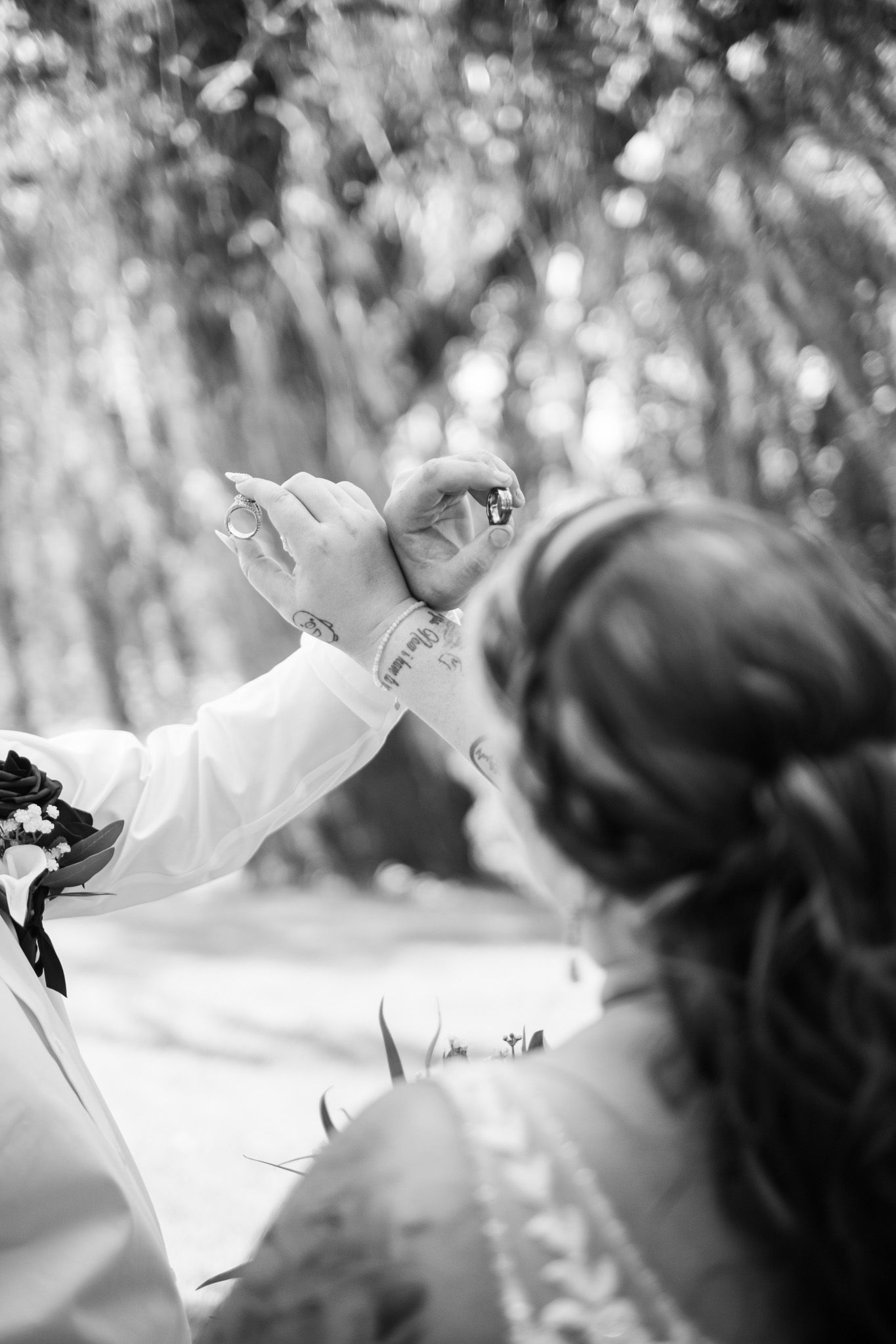 A delicate white flower with petals unfurling against a soft, blurred background in black and white photography.
