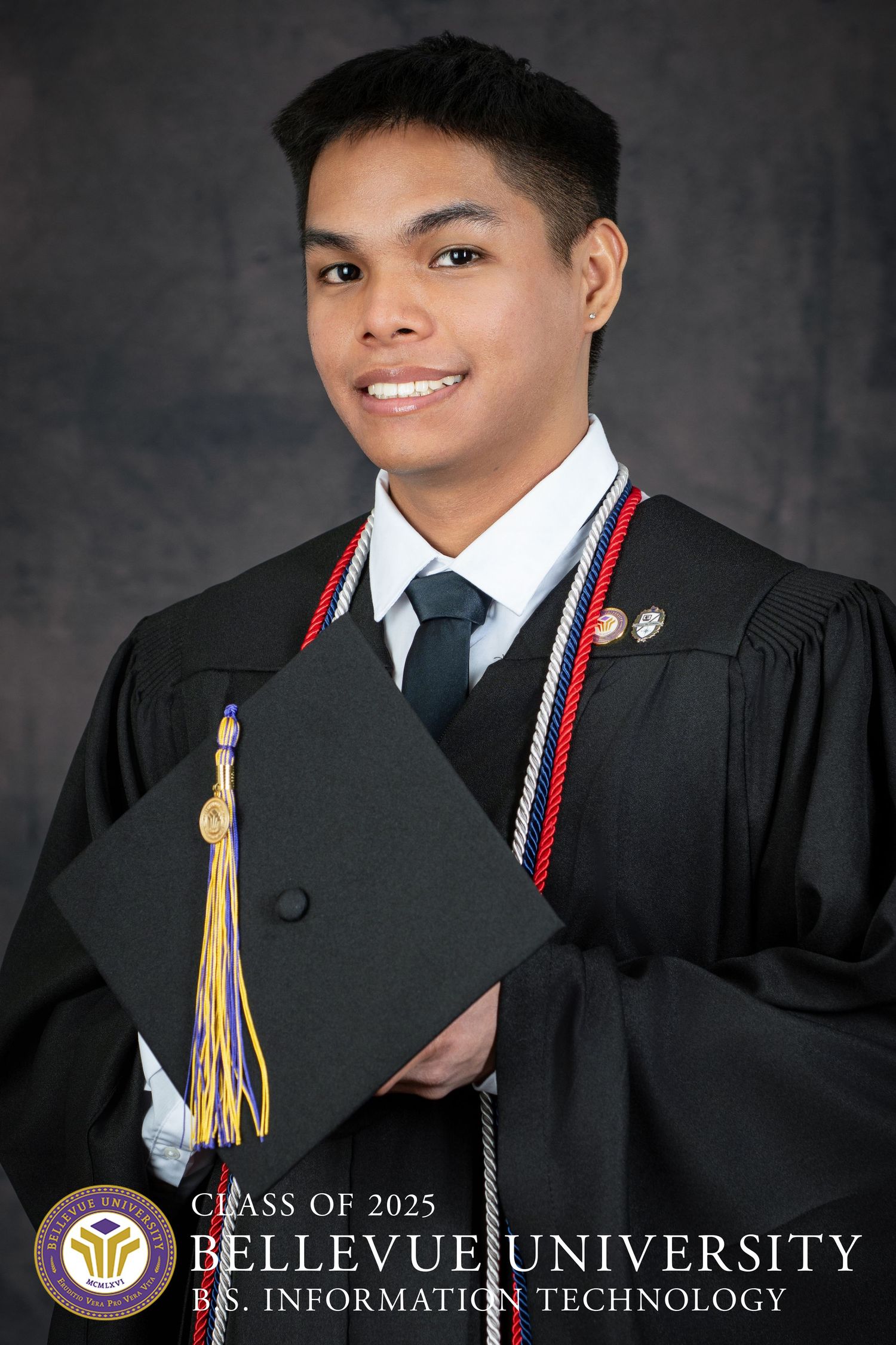 Graduate in academic regalia holds diploma from Bellevue University for BS Information Technology by photographer in Omaha.