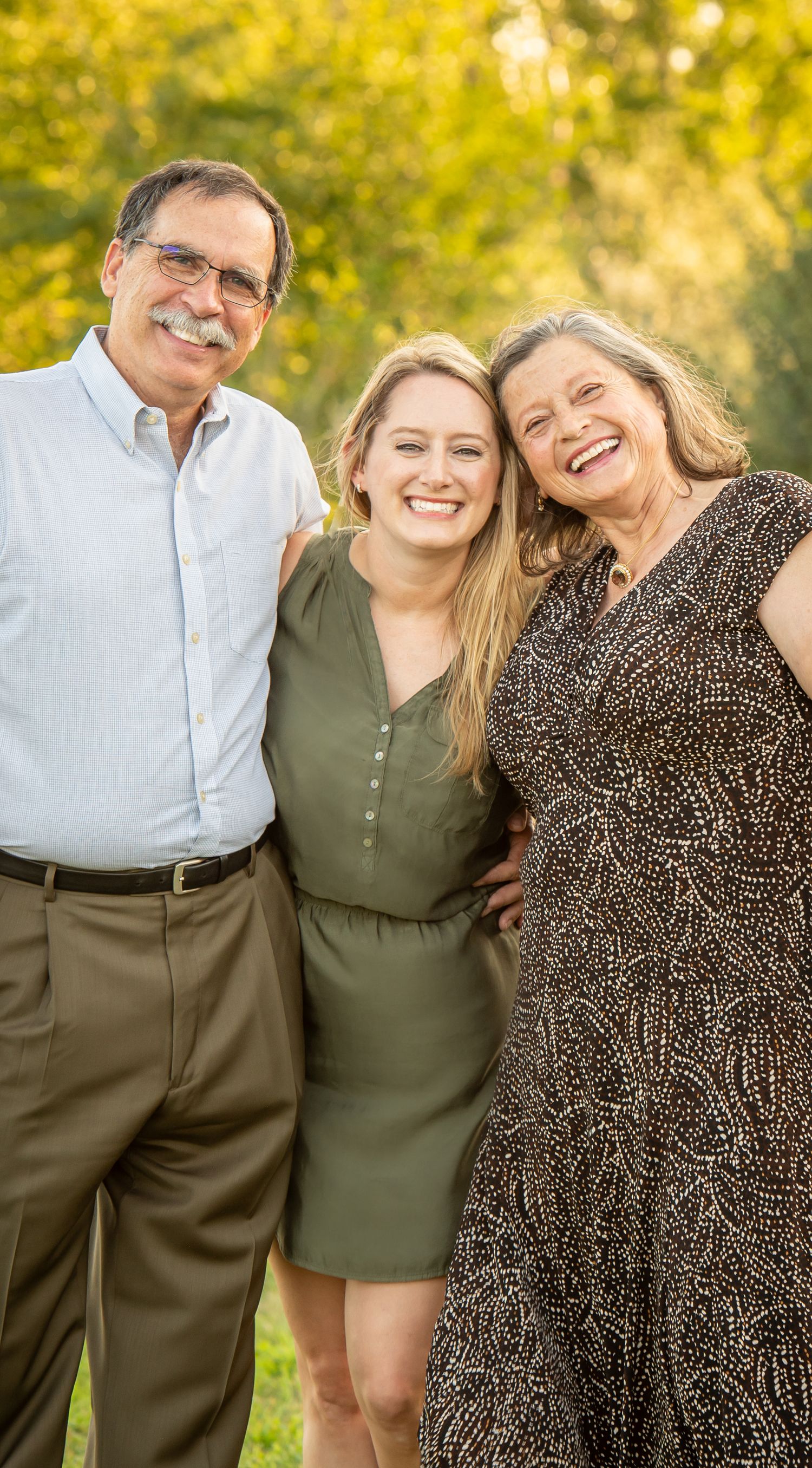 Chalco Lake Family Photography - A cheerful family poses together outdoors on a sunny autumn day with golden foliage in the background.