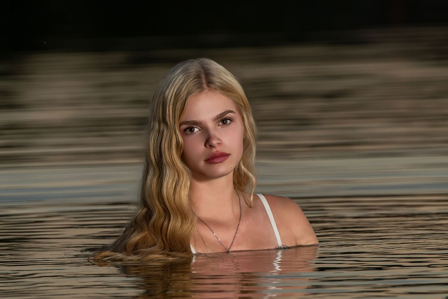 Omaha Senior Photography - Photographer in Omaha - Portrait of woman in water during sunset with golden hair flowing.