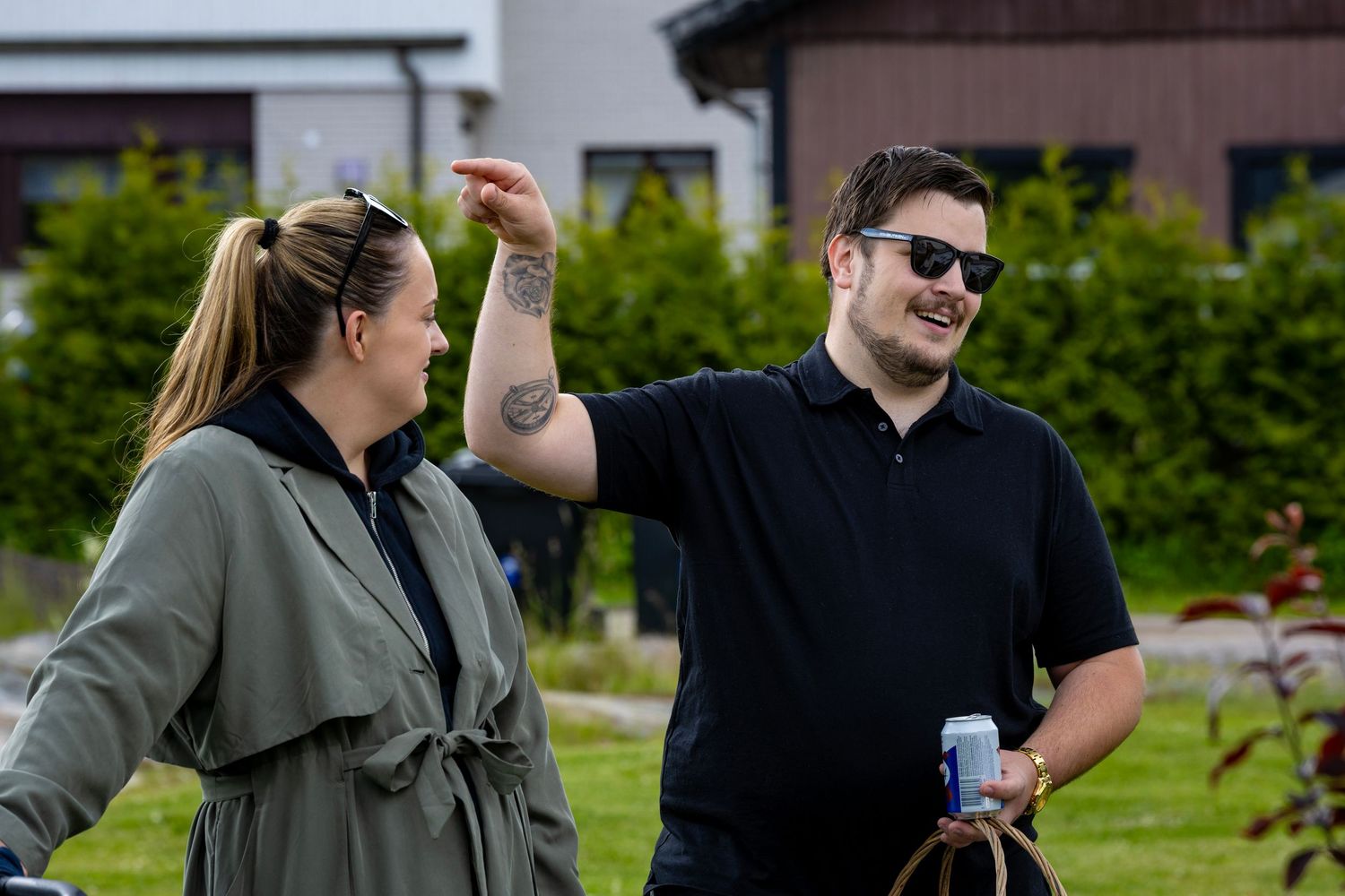 Två vänner delar en lättsam stund i en trädgård.