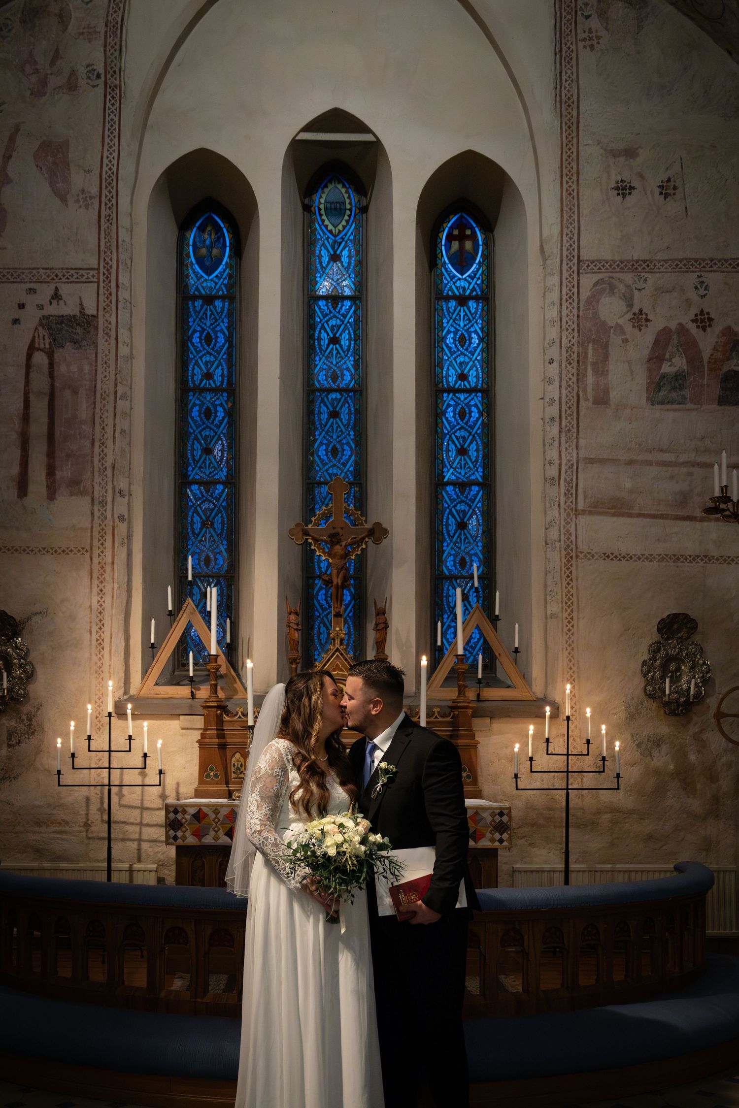 Ett romantiskt ögonblick fångat under en kyrklig vigselceremoni med levande ljus.