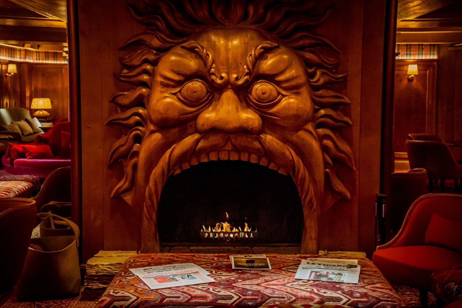 Ornate carved wooden wall panels with decorative faces and designs adorning a luxurious interior space.