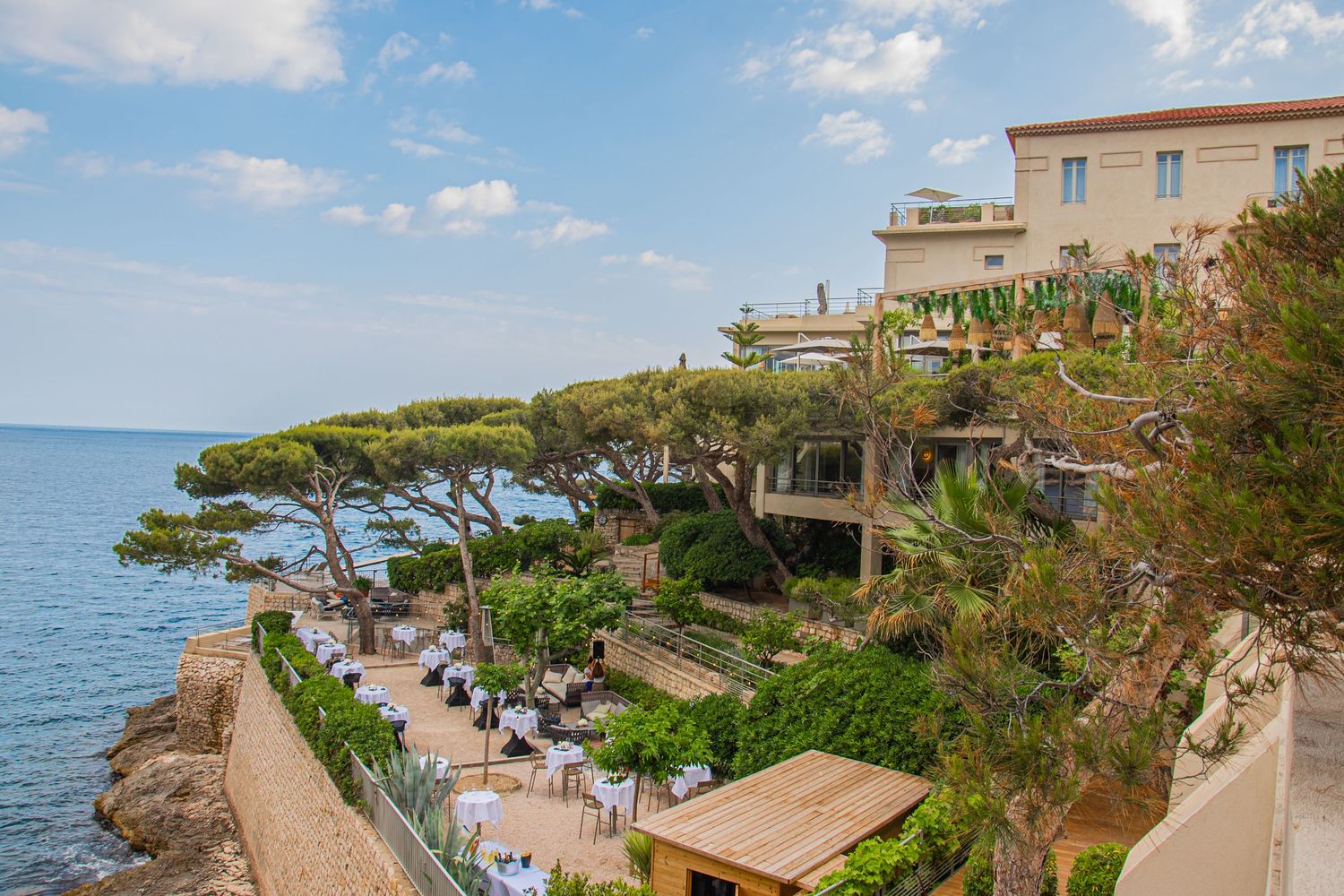 Mediterranean coastal walkway with stone balustrades winding along scenic cliffs overlooking the ocean at sunset.