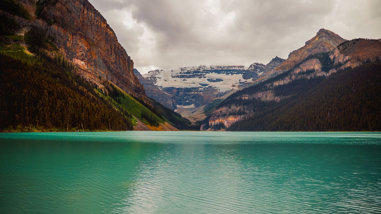 Panoramic view of Lake Louise in Banff National Park showcasing turquoise waters and snow-capped mountains.