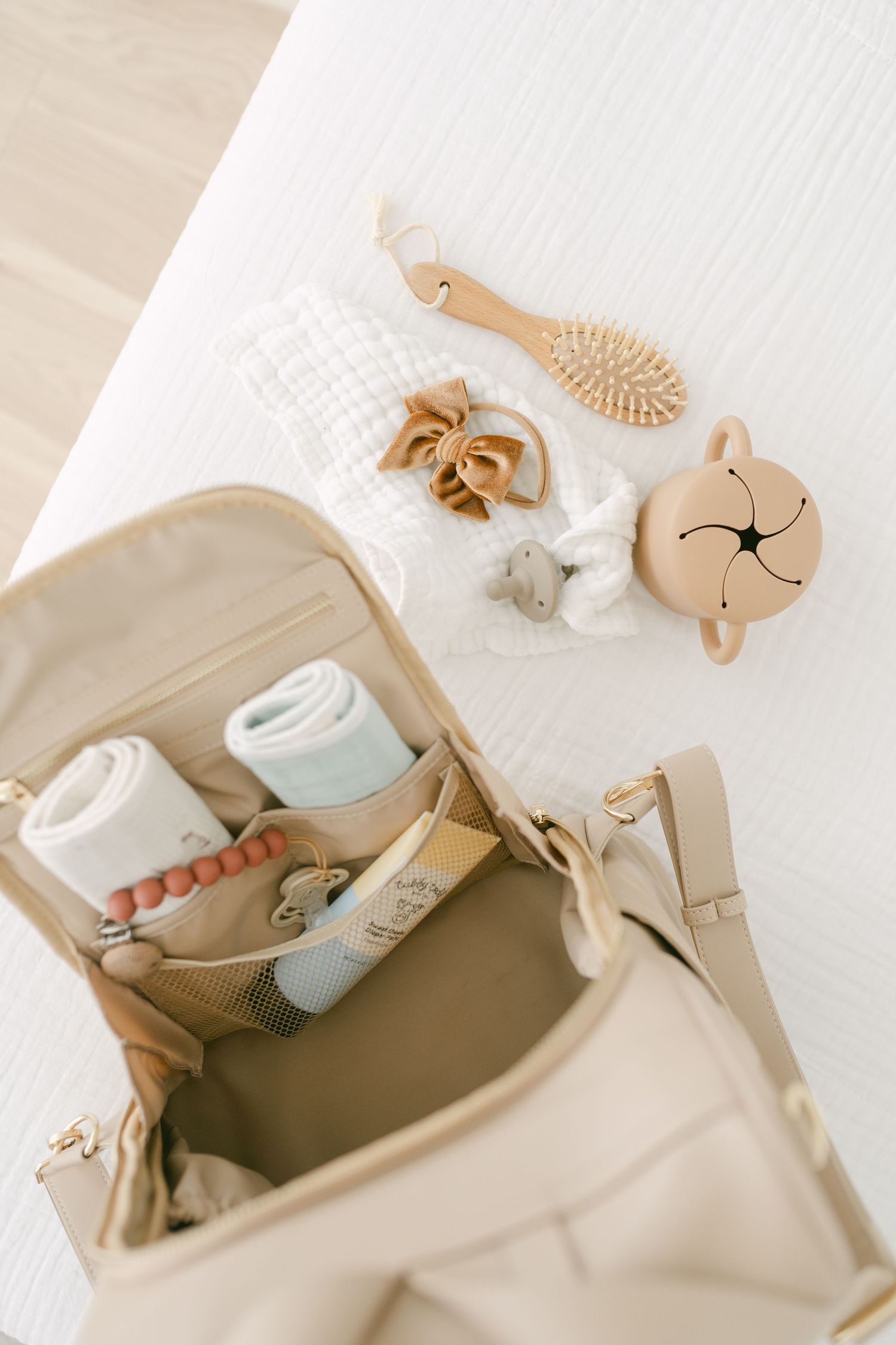 Open diaper bag showing baby essentials and grooming accessories.