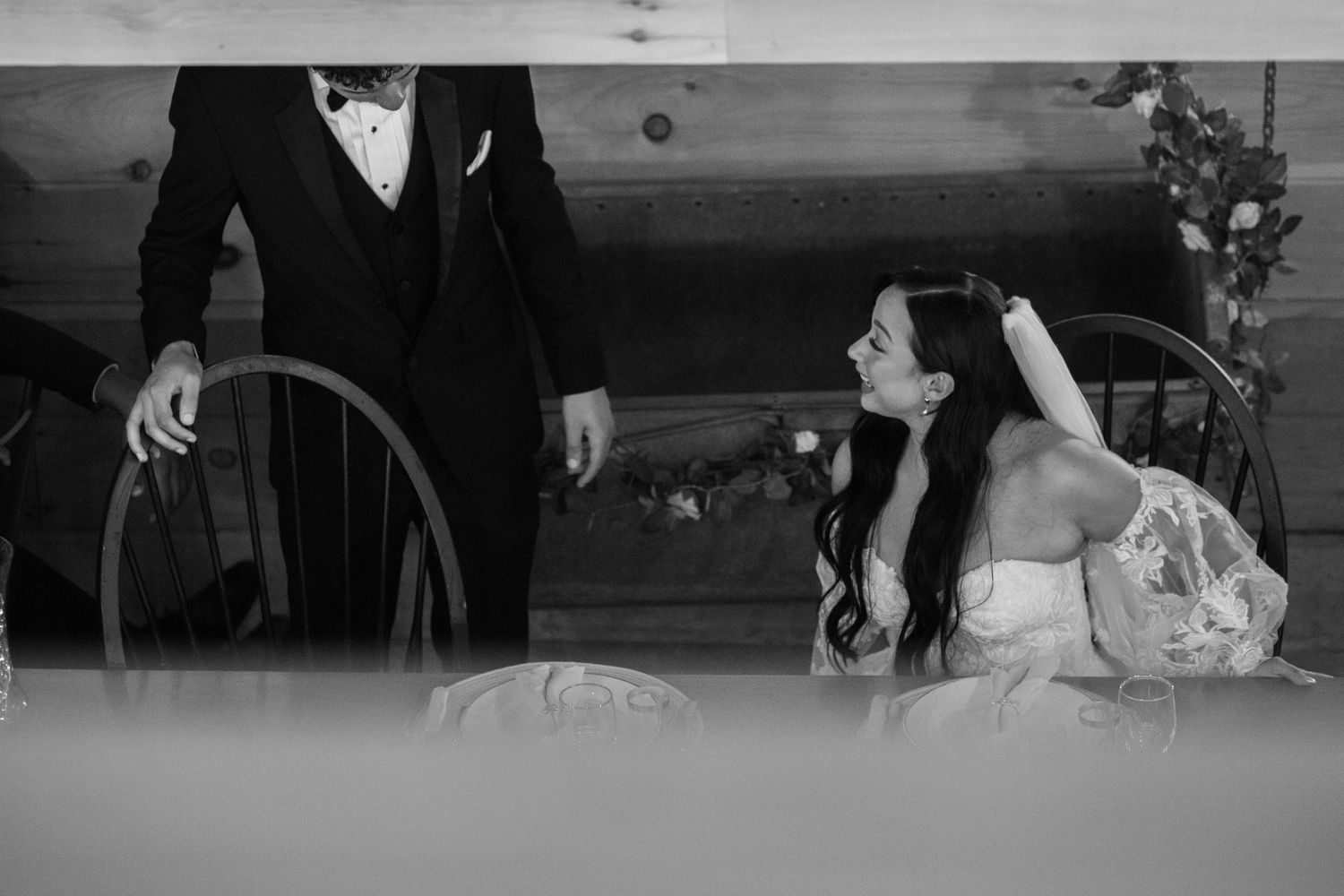 Black and white vintage wedding photograph showing the couple in formal attire during a romantic moment together.