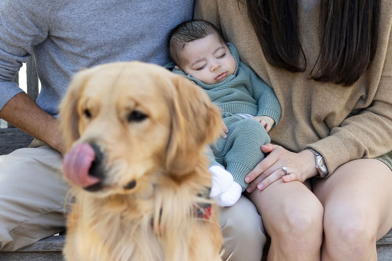A sleepy child rests peacefully next to a Golden Retriever dog during a family moment at home.