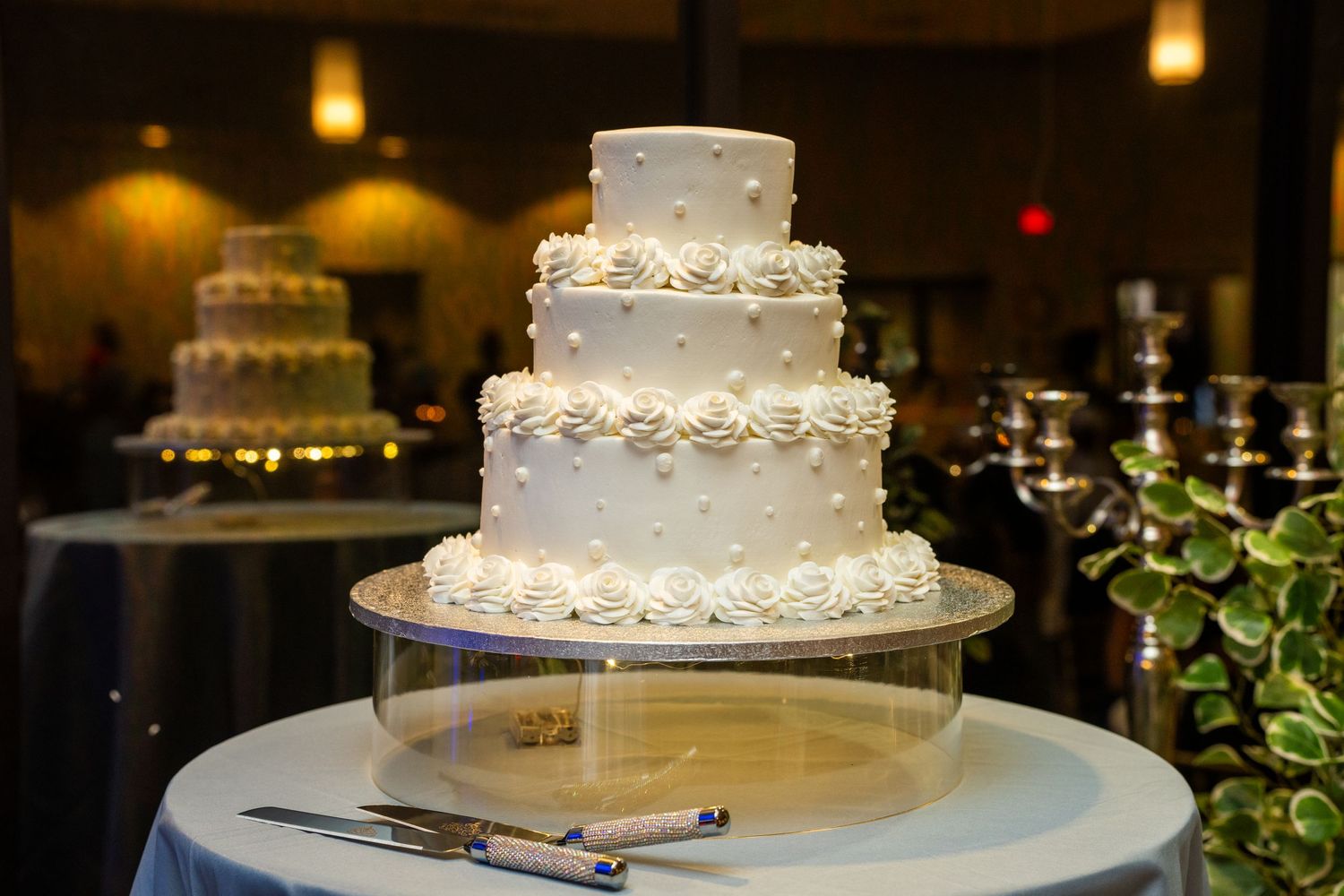 An elegant white wedding cake with delicate floral decorations displayed on a table.