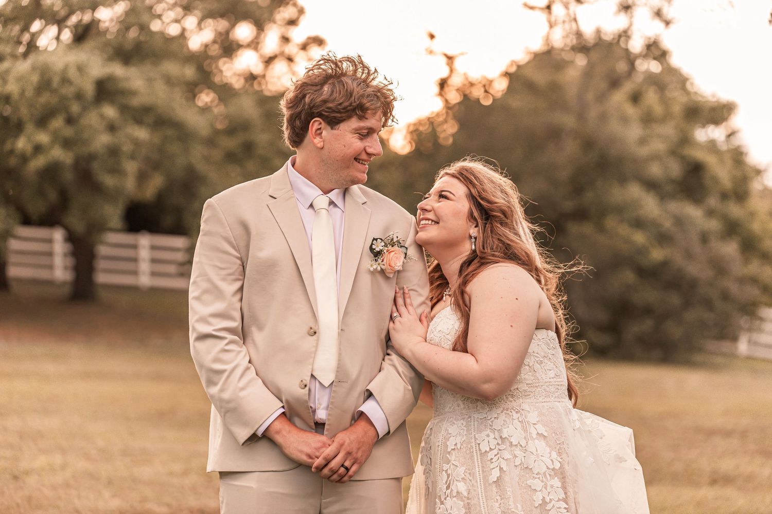 A couple sharing a joyful moment together during their outdoor wedding photoshoot at golden hour.