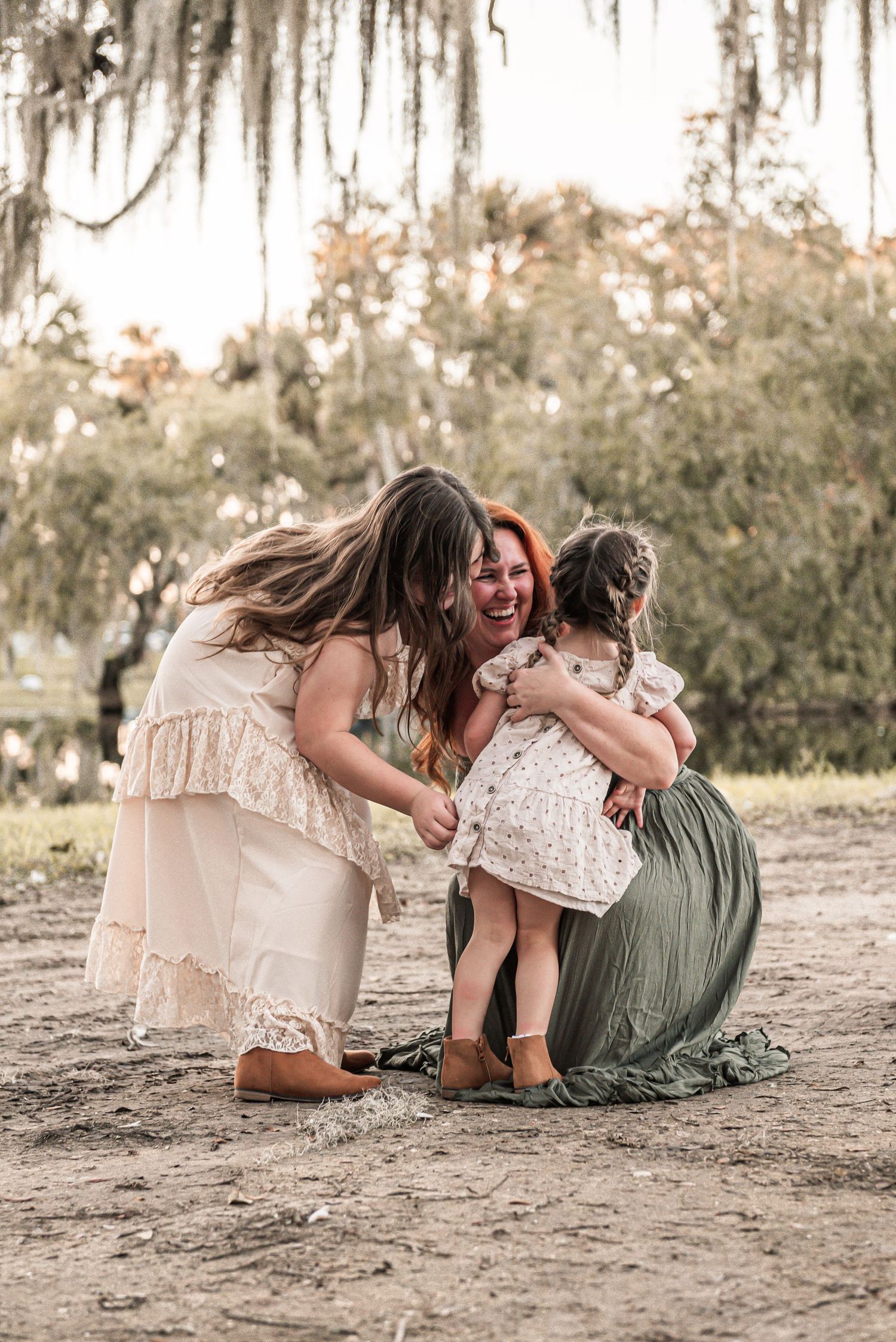A heartwarming family moment captured outdoors under Spanish moss at golden hour.