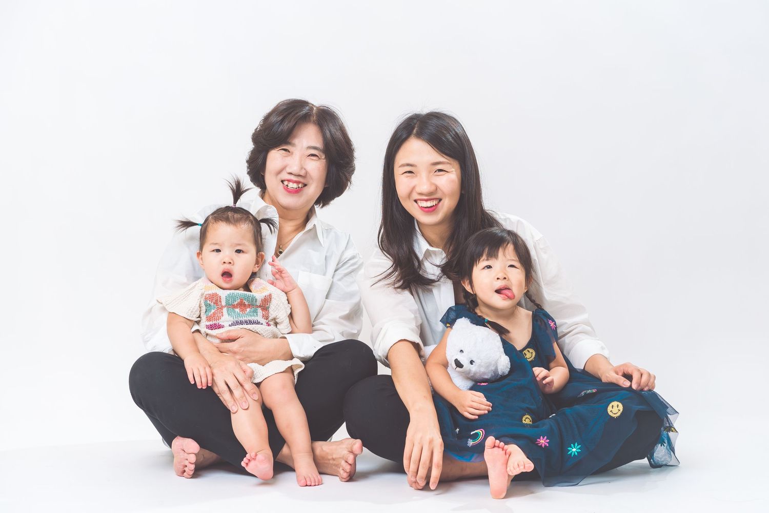 Family portrait against white background showing joy and laughter.