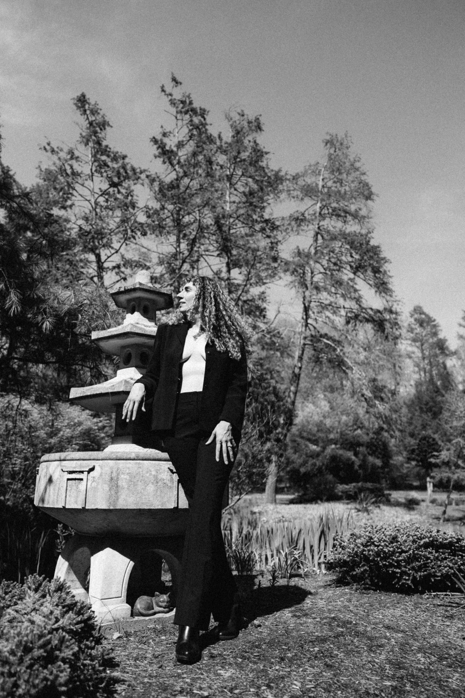 Black and white sequence showing person in dark outfit performing acrobatic movements outdoors.