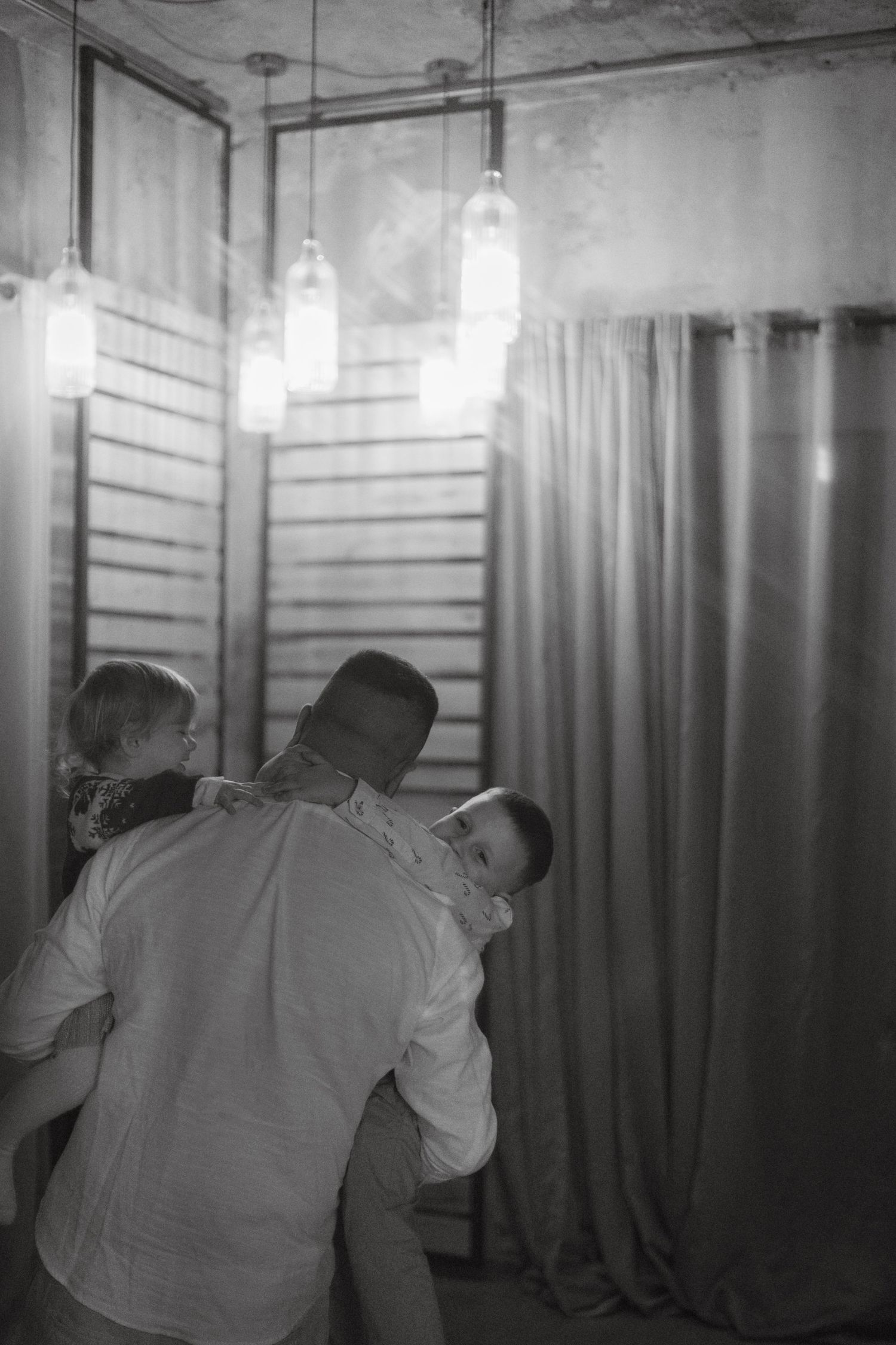 An intimate family moment captured in black and white with pendant lighting.