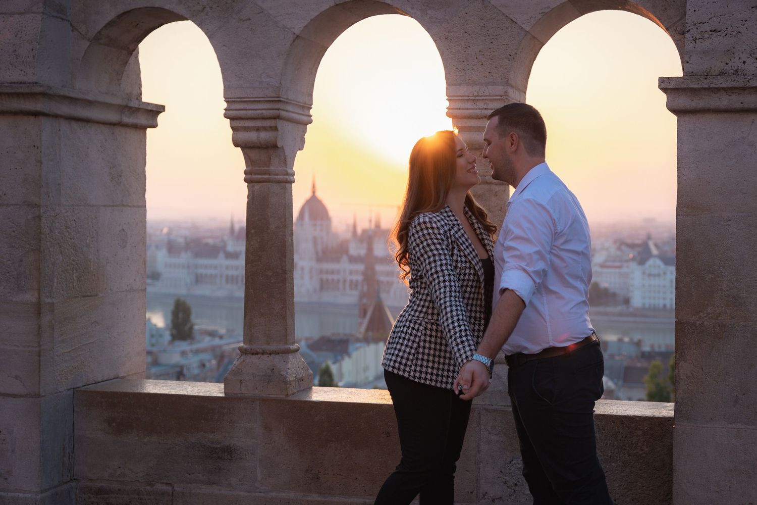 Golden hour portrait session with stone columns and city views in background.