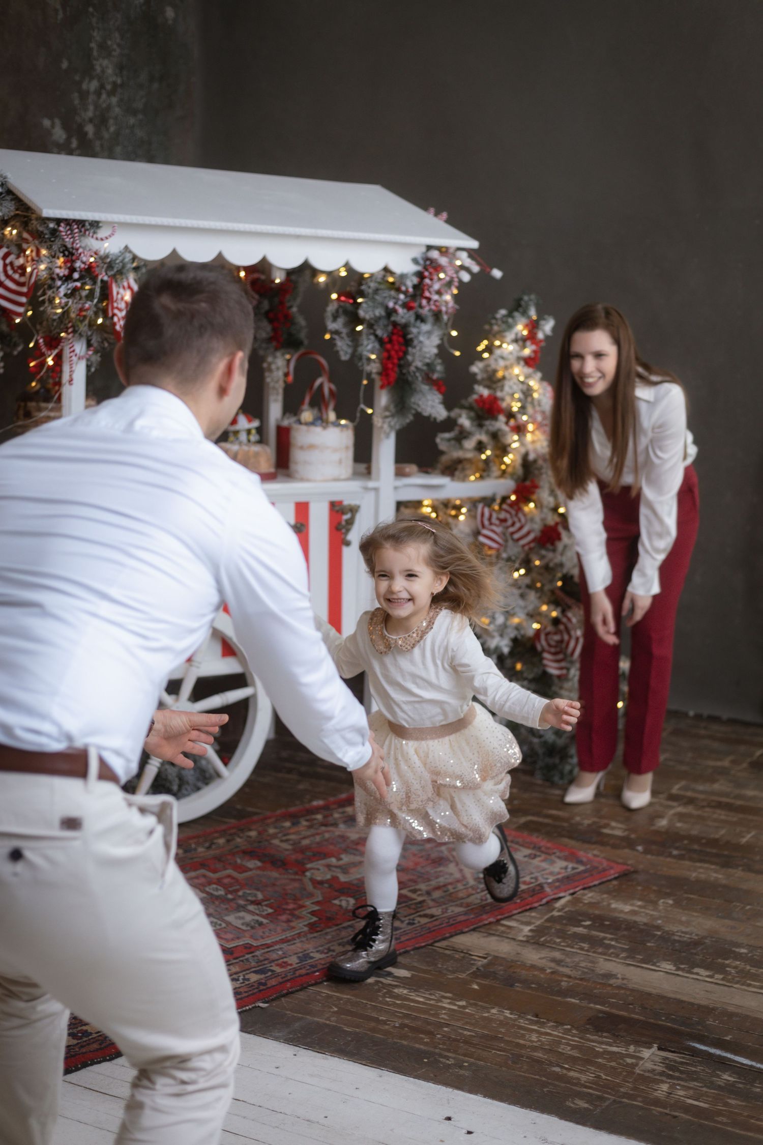 A festive family photo session with Christmas decorations and a running child.
