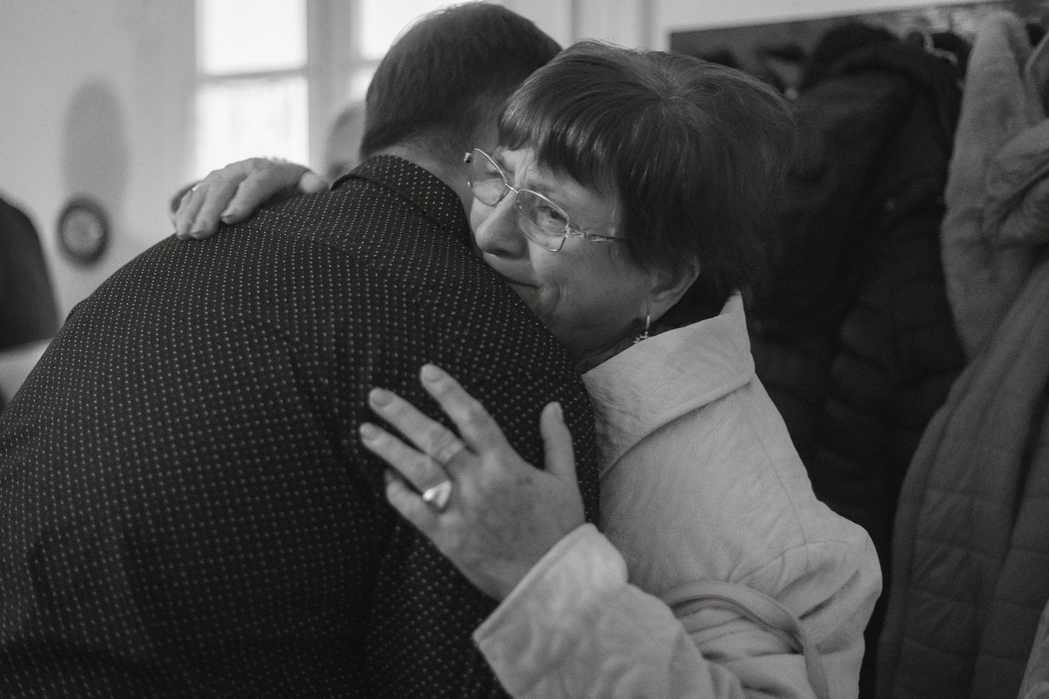 Emotional black and white photograph of two people embracing in an intimate moment.