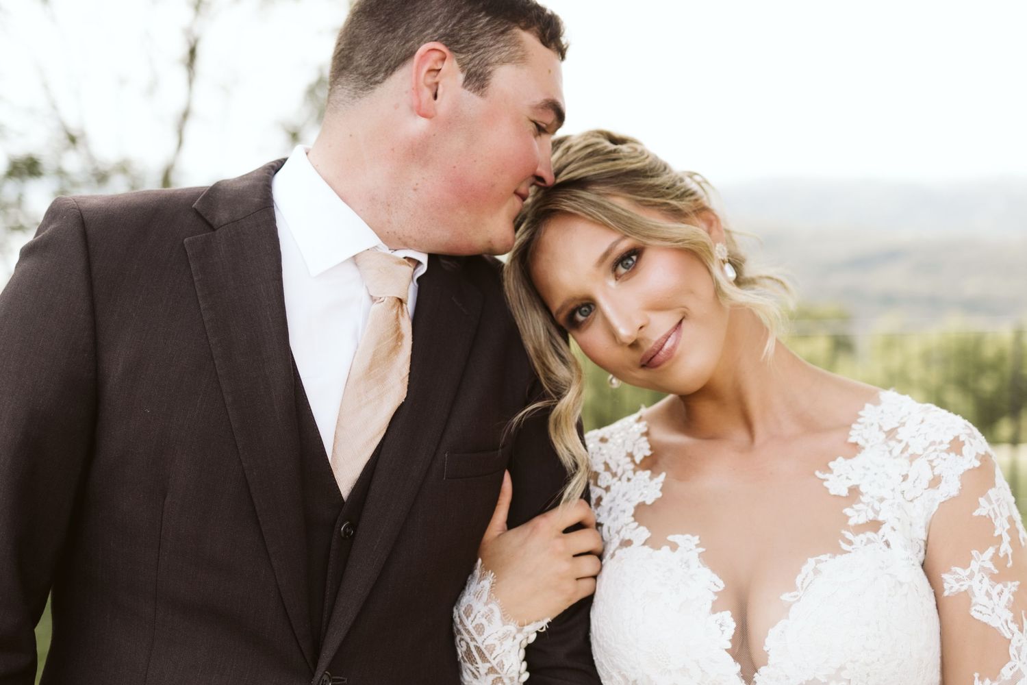 Intimate wedding portrait moment captured against mountain backdrop.