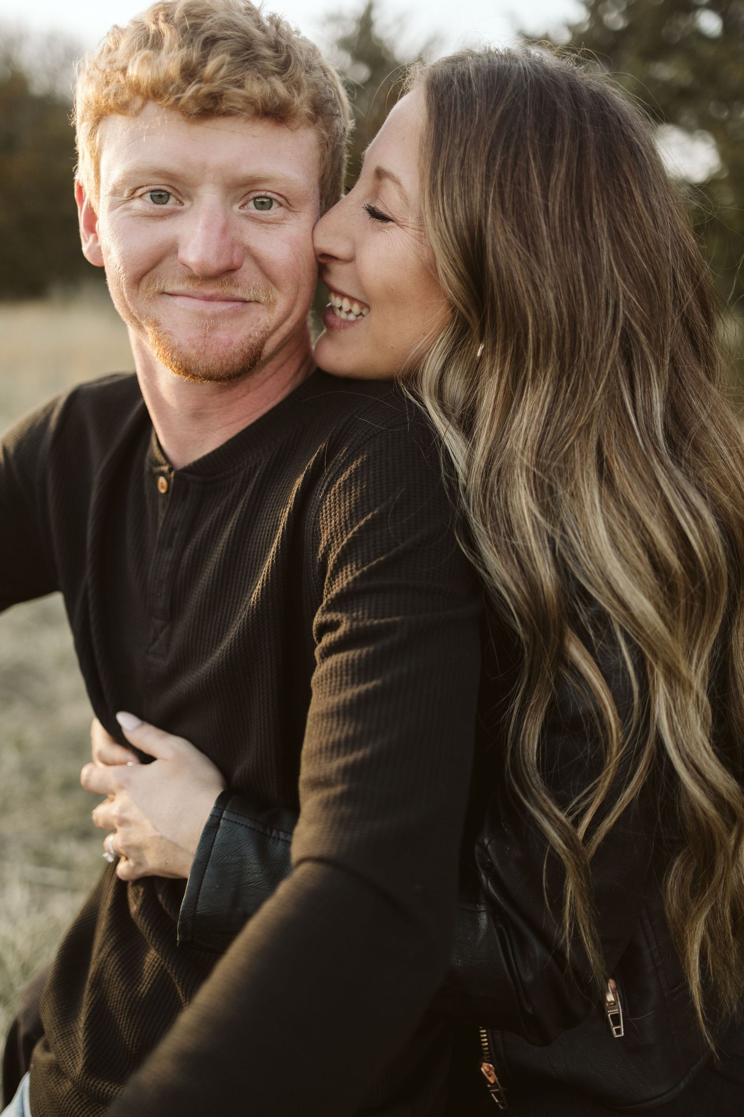 An intimate couple sharing a tender moment outdoors at golden hour.