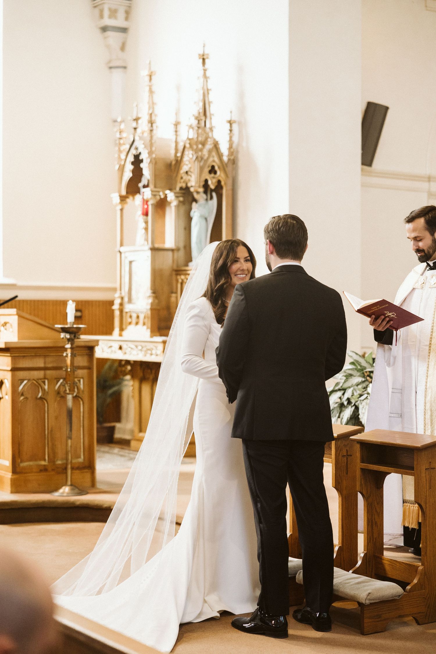 A couple stands at the altar exchanging vows in a traditional church wedding ceremony.