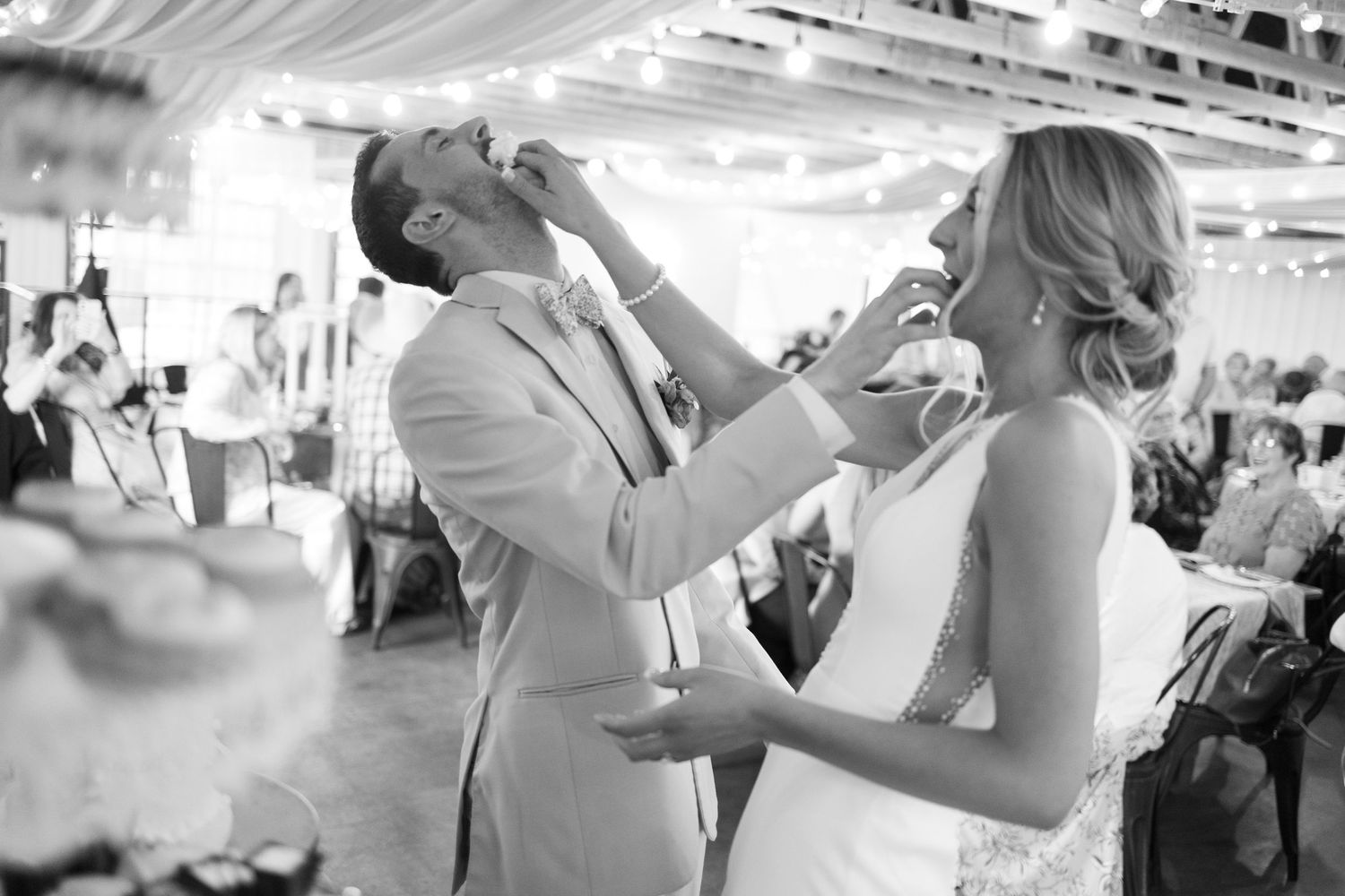 Couple shares champagne toast during wedding reception in indoor venue.
