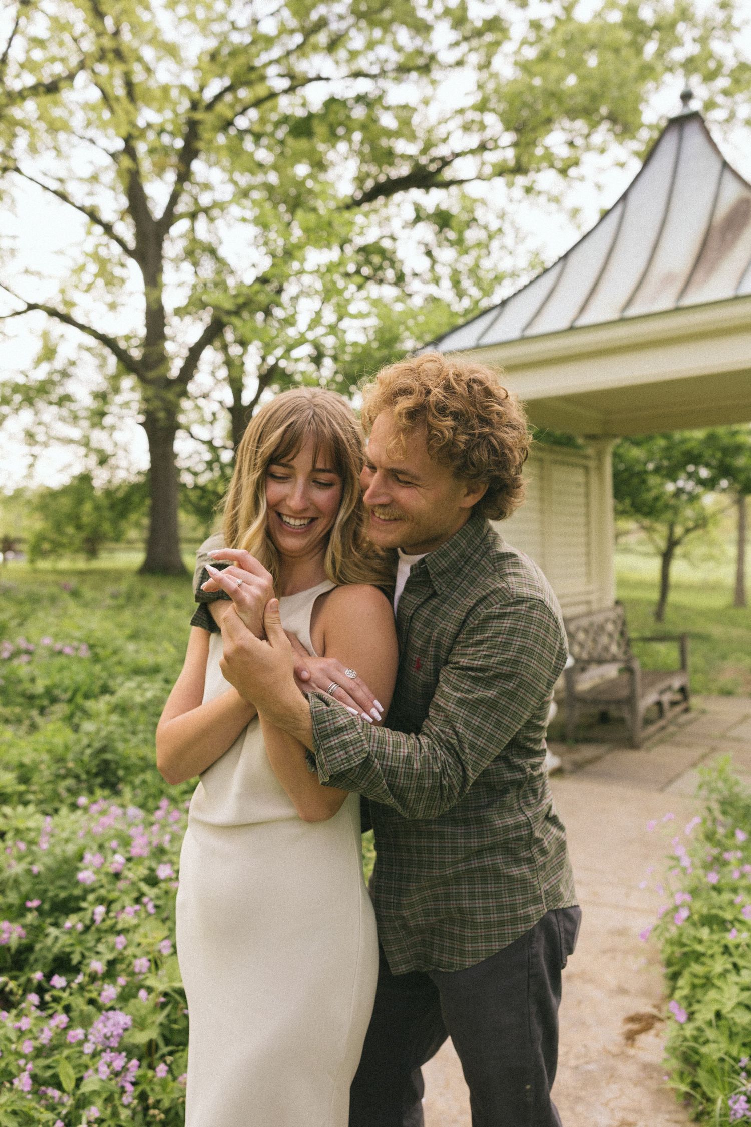 A couple shares loving moments and laughter along a garden path in a series of candid photos.