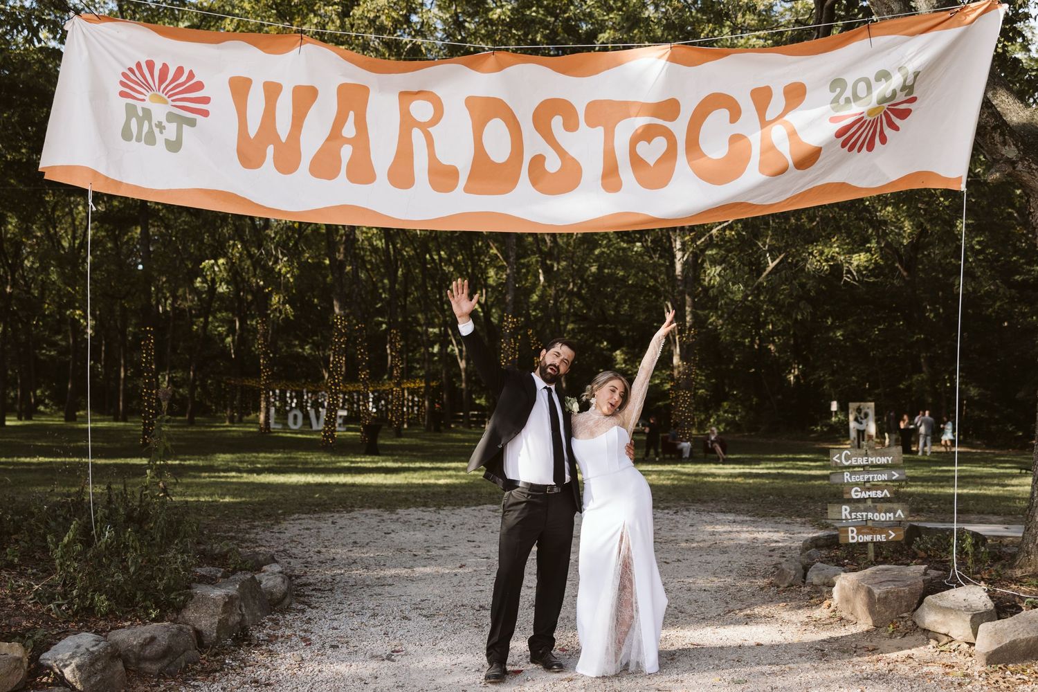 A festive orange and white 'Warpstock' banner hangs between trees at an outdoor celebration.