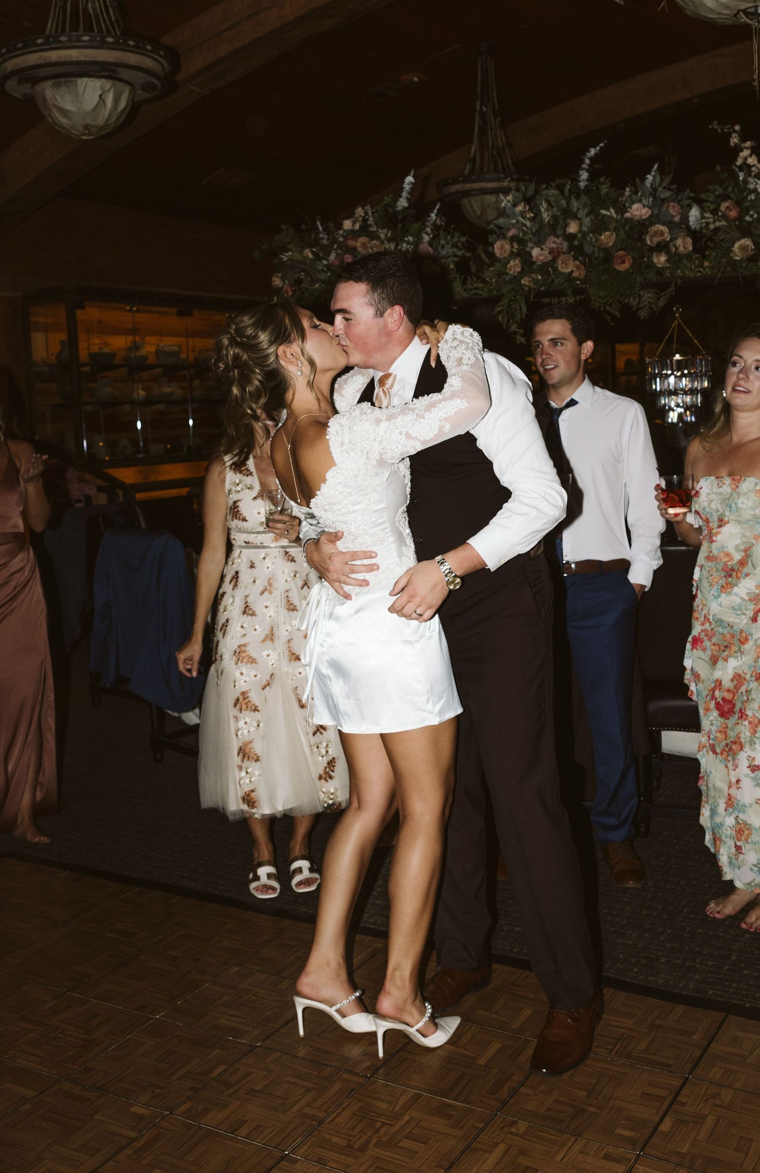 Wedding reception dance moment with the bride in a chic short white dress.