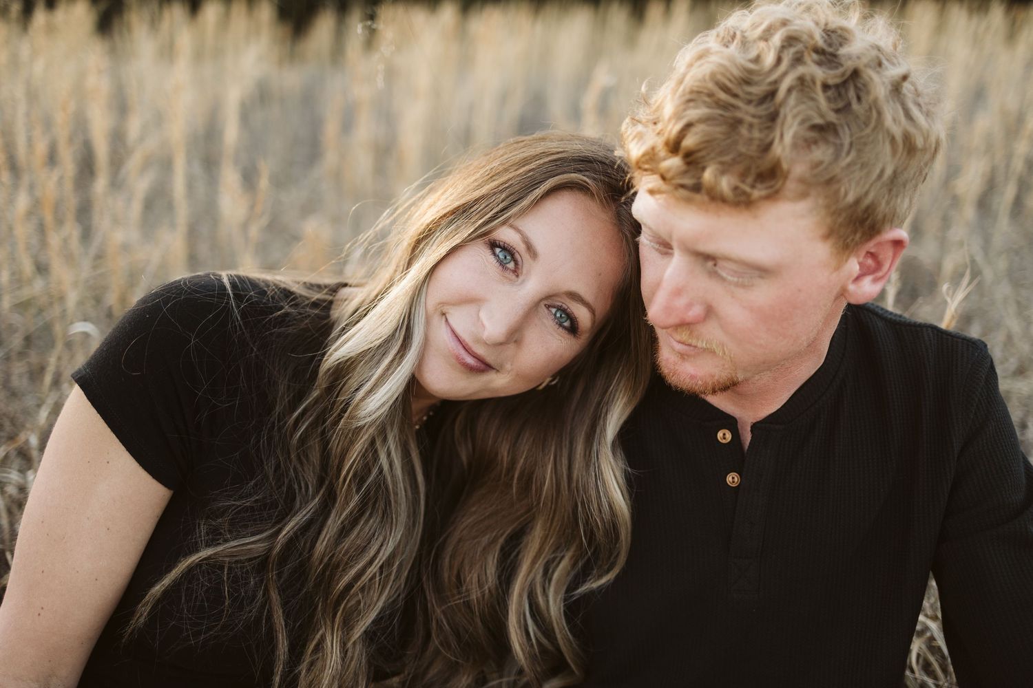Intimate close-up of couple sharing tender moment in autumn field.