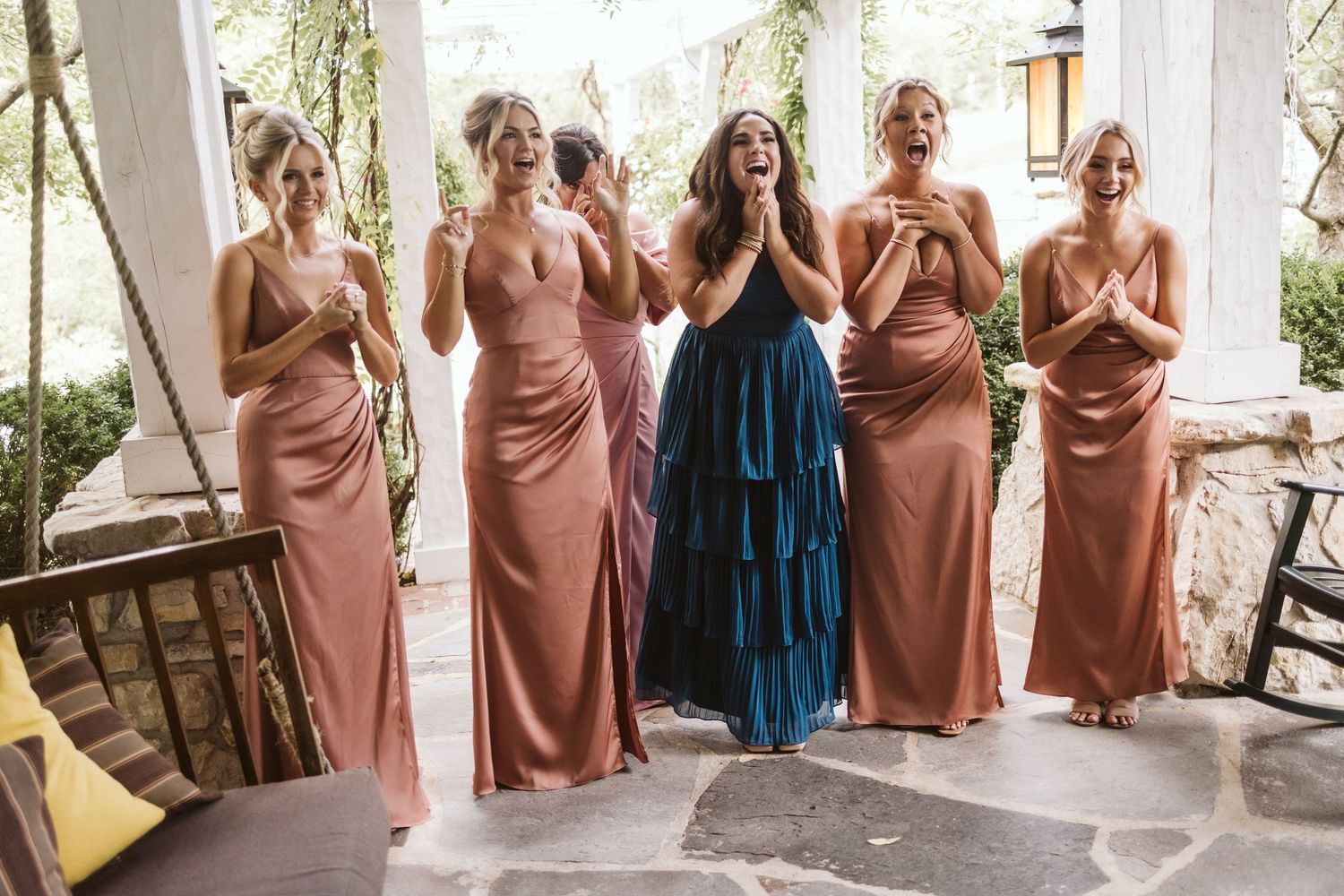Bridesmaids in pink dresses share an emotional moment before the ceremony.