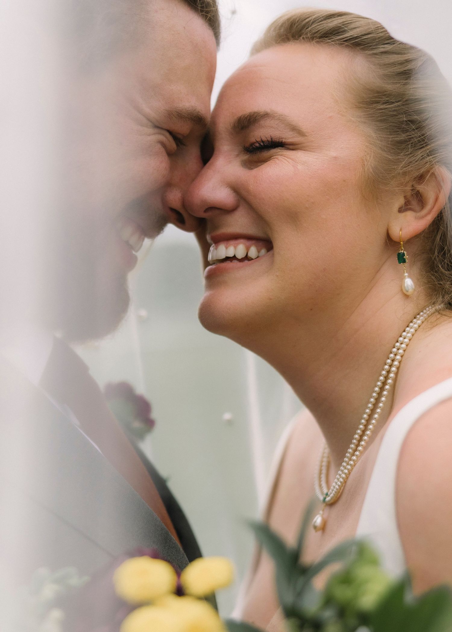 An intimate wedding portrait showing a tender moment of laughter and joy between newlyweds.