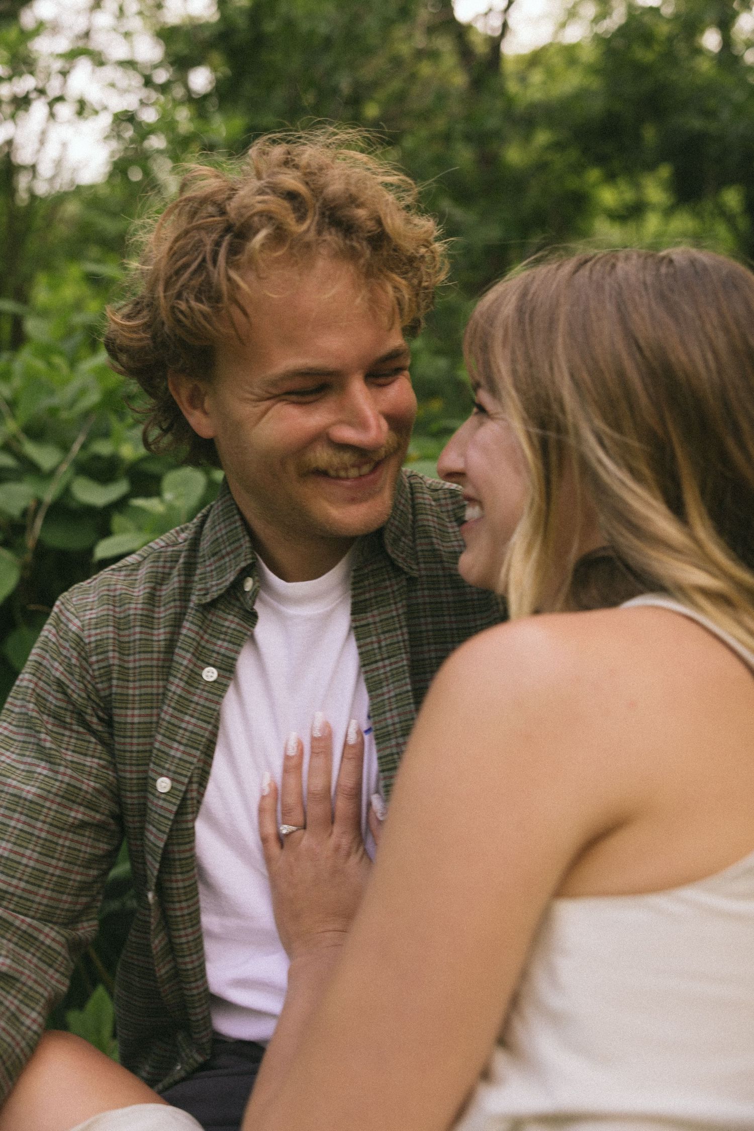 A candid sequence showing a young couple sharing playful and affectionate moments outdoors in a natural setting.