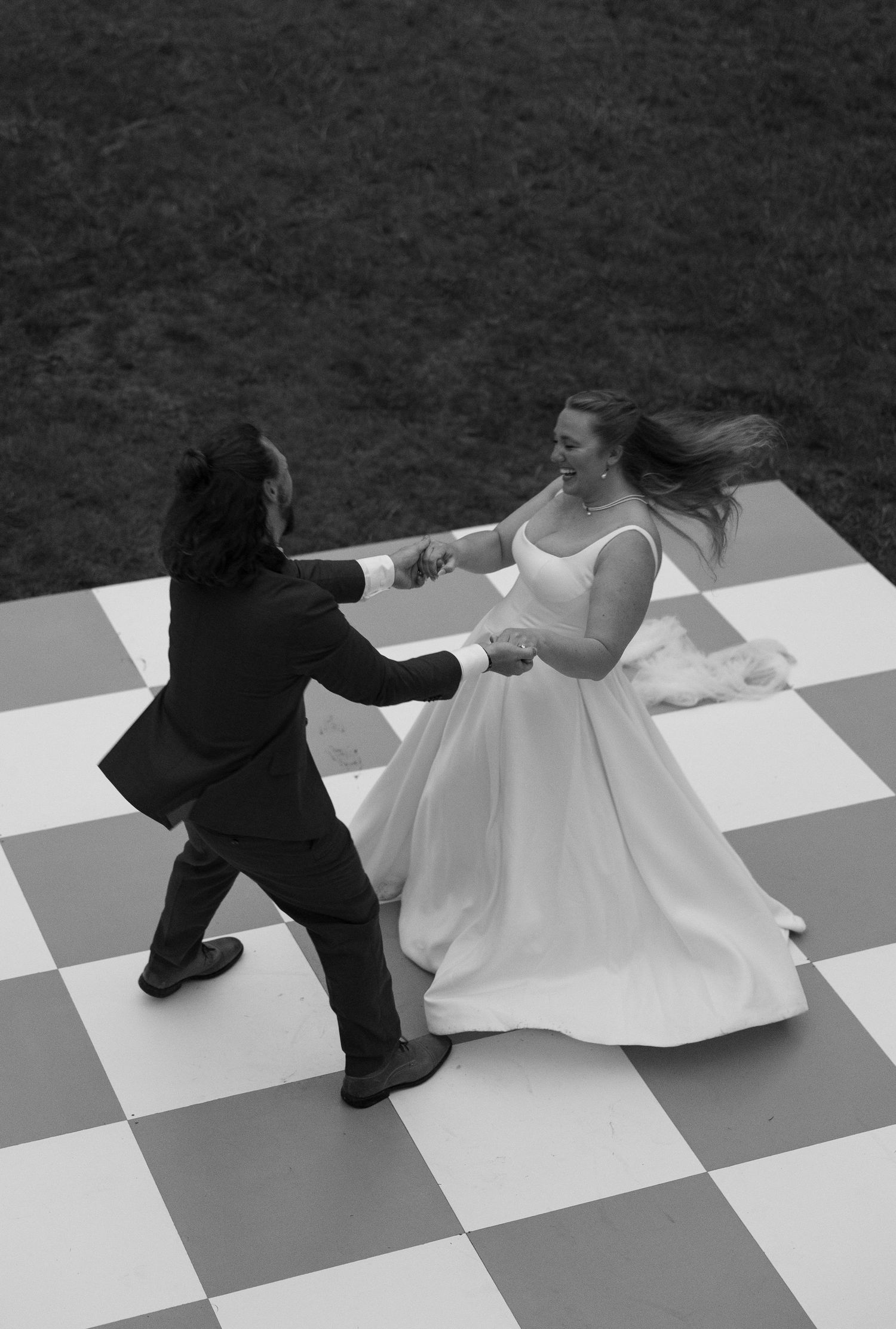 A black and white stop-motion sequence showing a figure tumbling across a checkered surface in dynamic motion.
