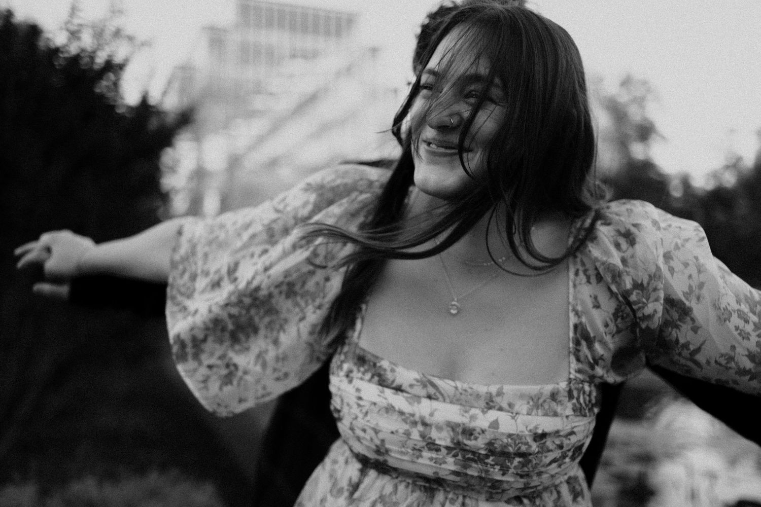 A joyful moment captured in black and white showing someone dancing in a floral dress.